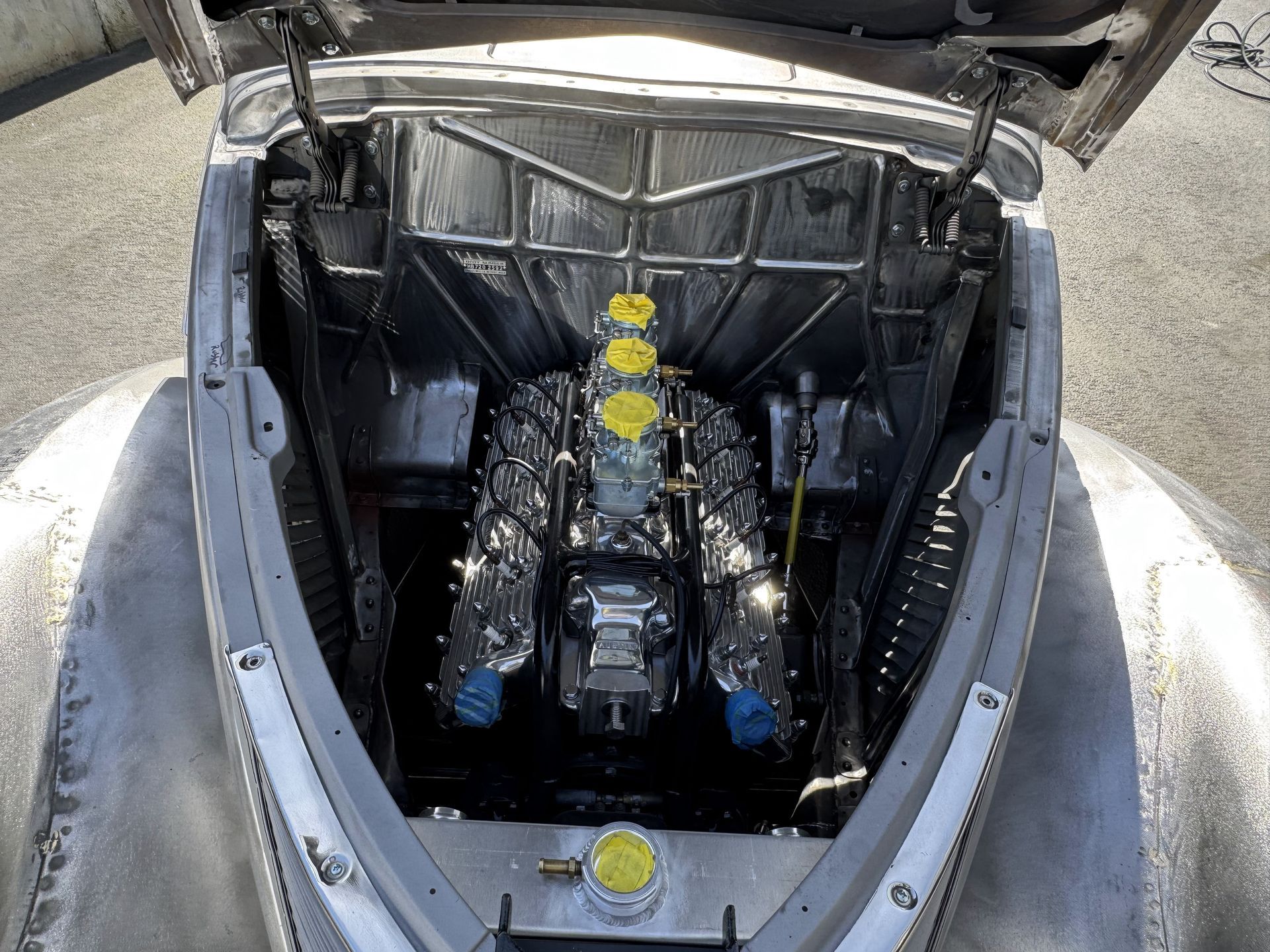 A close up of a car engine with the hood open