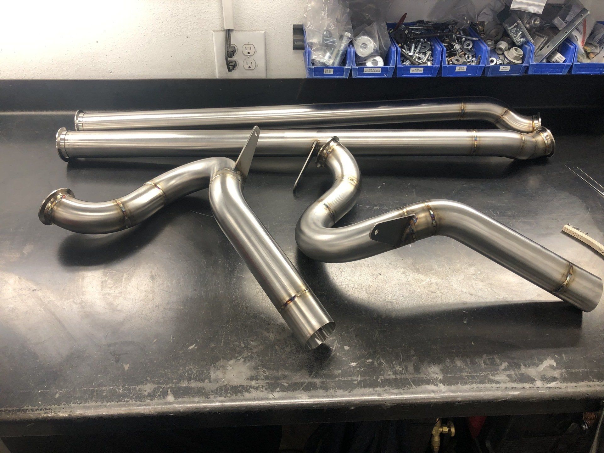 A bunch of stainless steel pipes are sitting on a table.