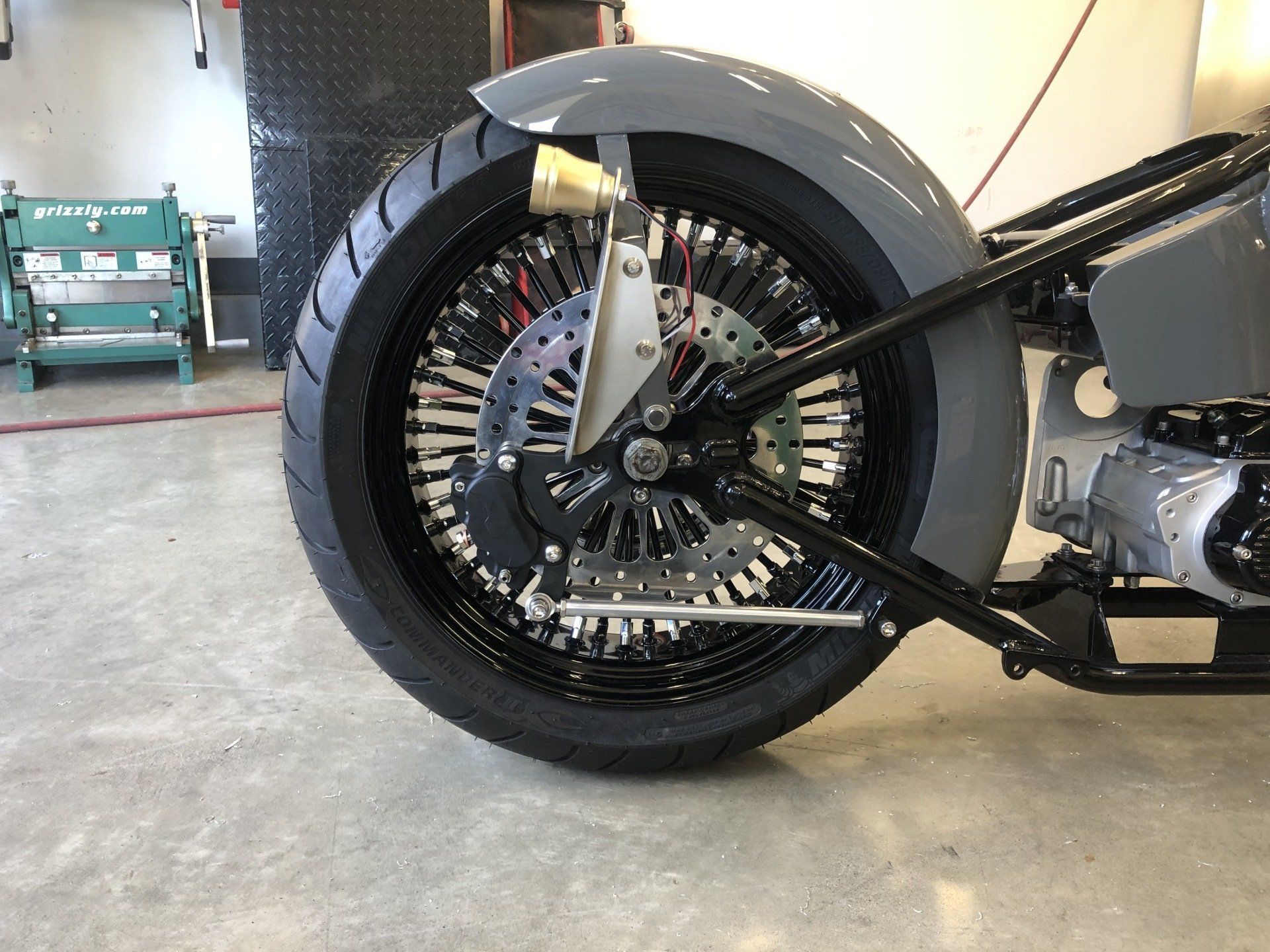 A close up of a motorcycle wheel in a garage