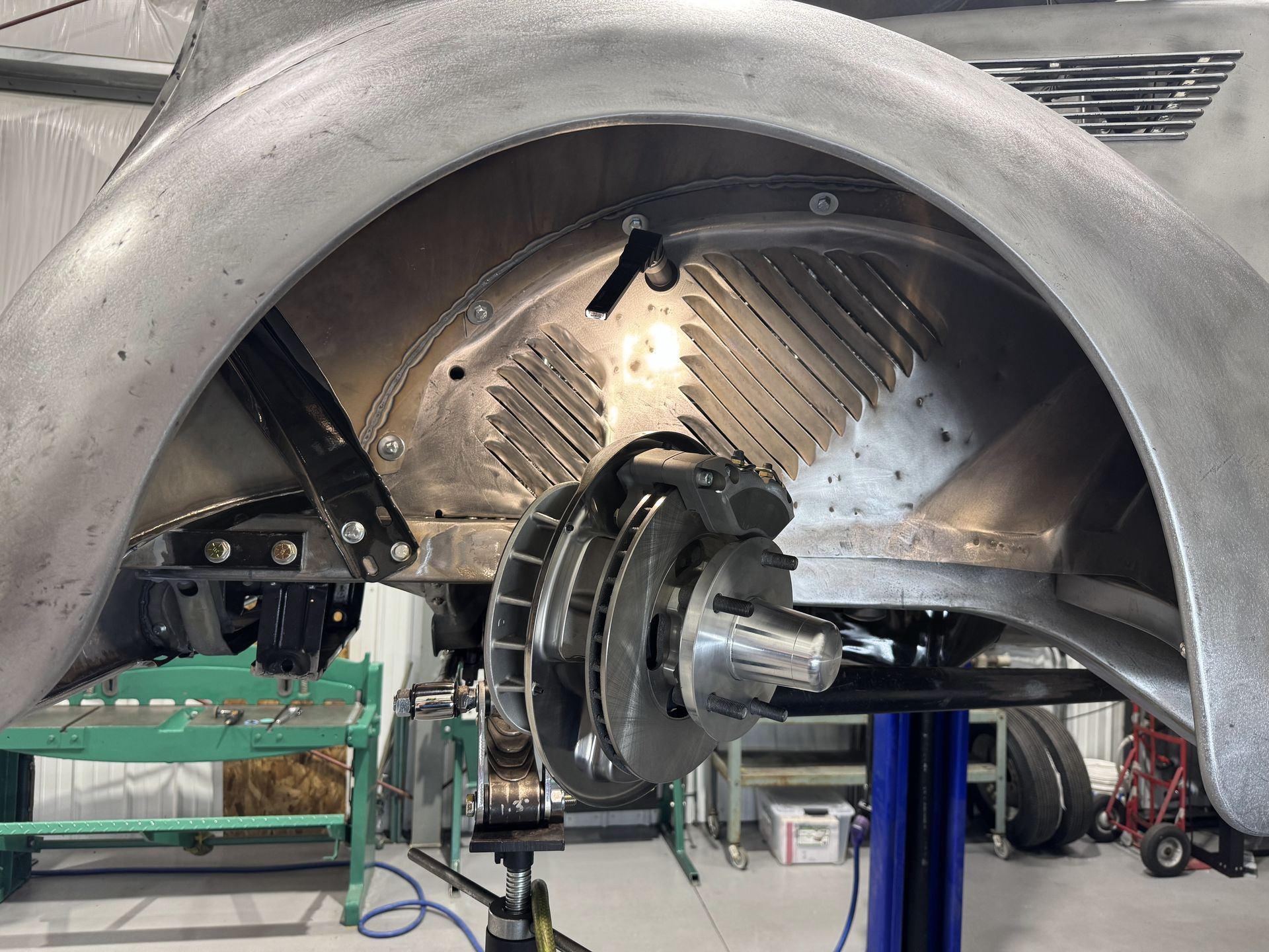 A car wheel is sitting on a lift in a garage
