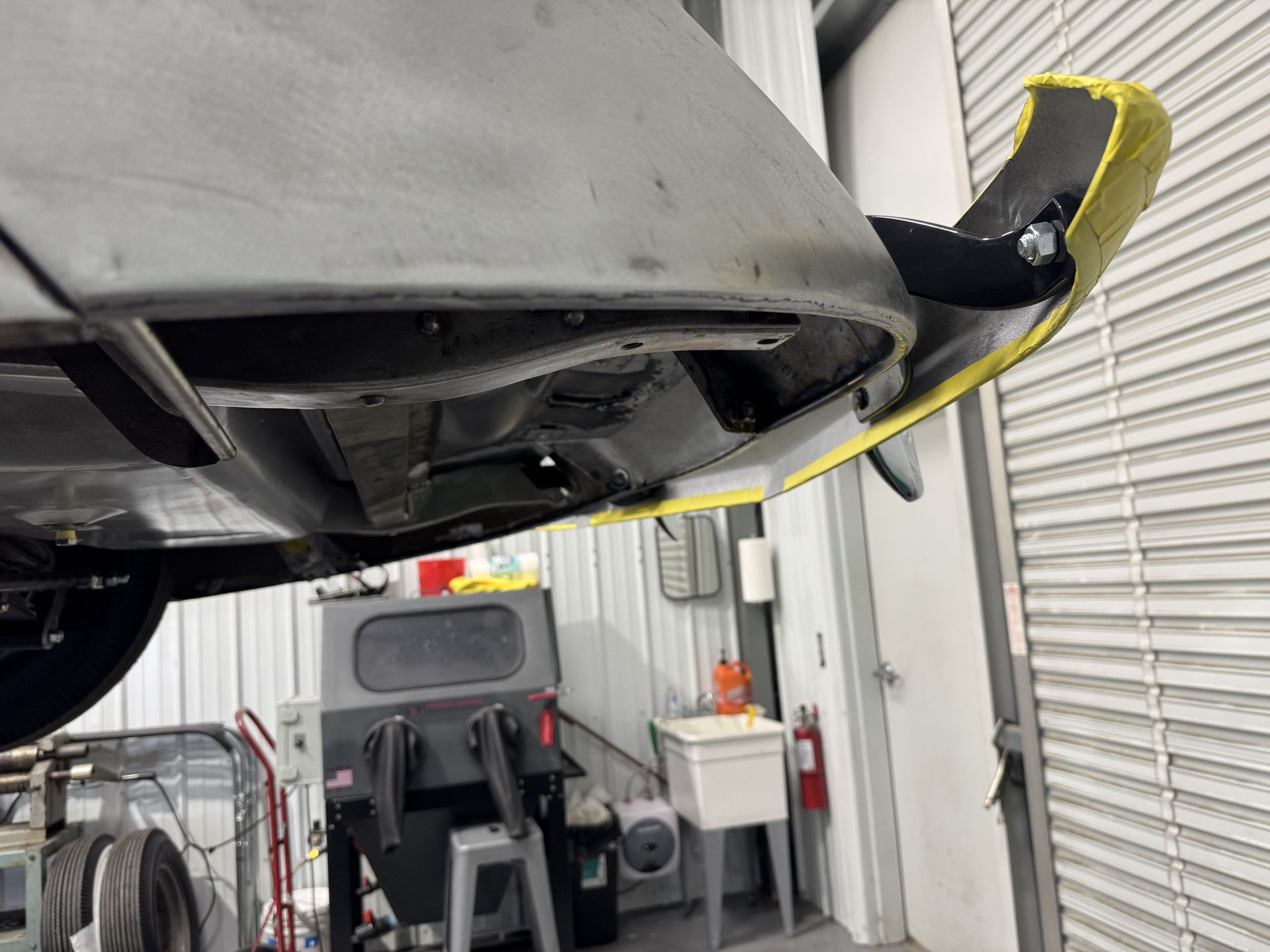 A car is sitting on a lift in a garage.