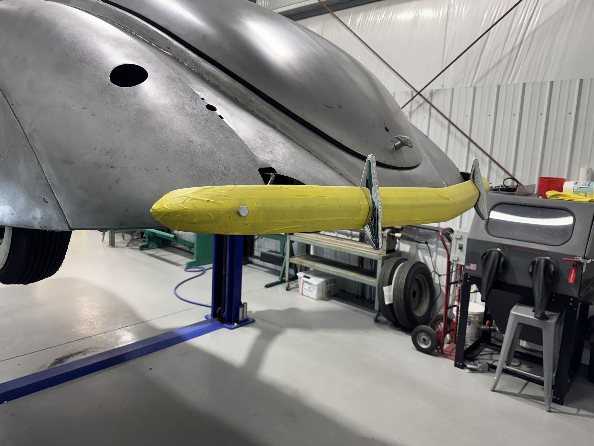 A car is sitting on a lift in a garage.