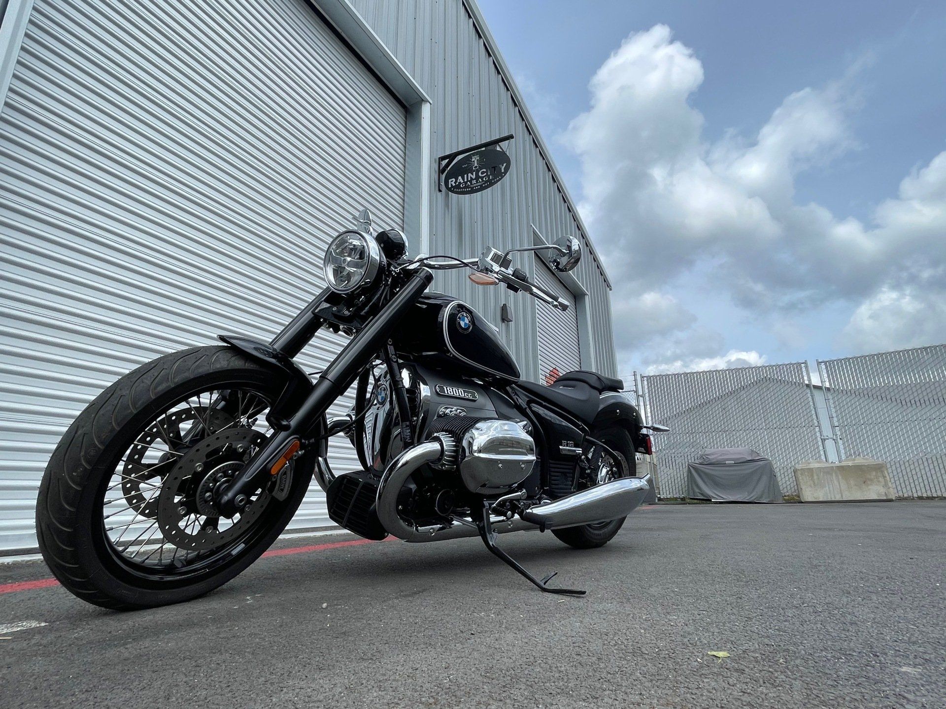 A black motorcycle is parked in front of a building.