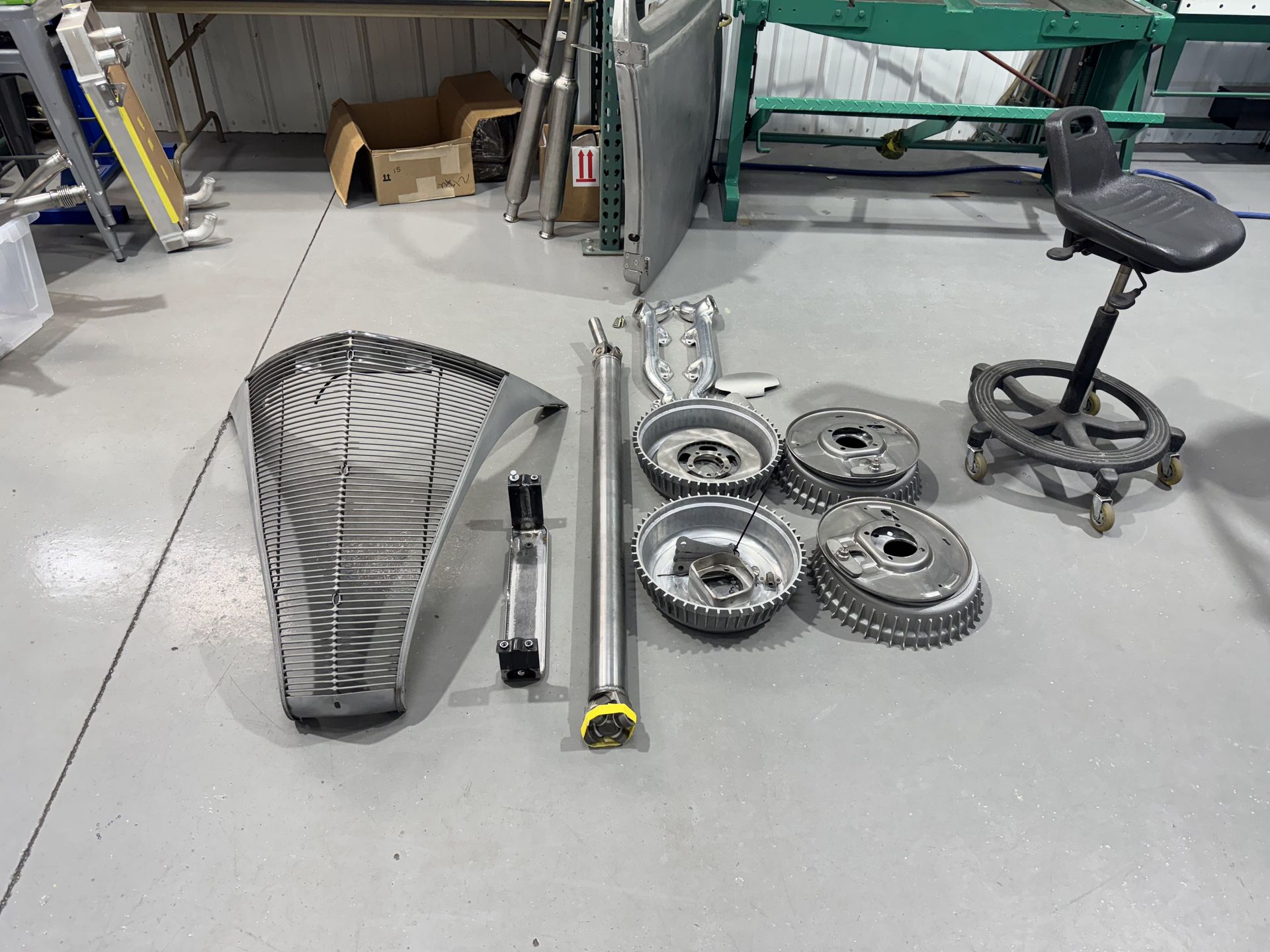 A bunch of tools are sitting on the floor in a garage.