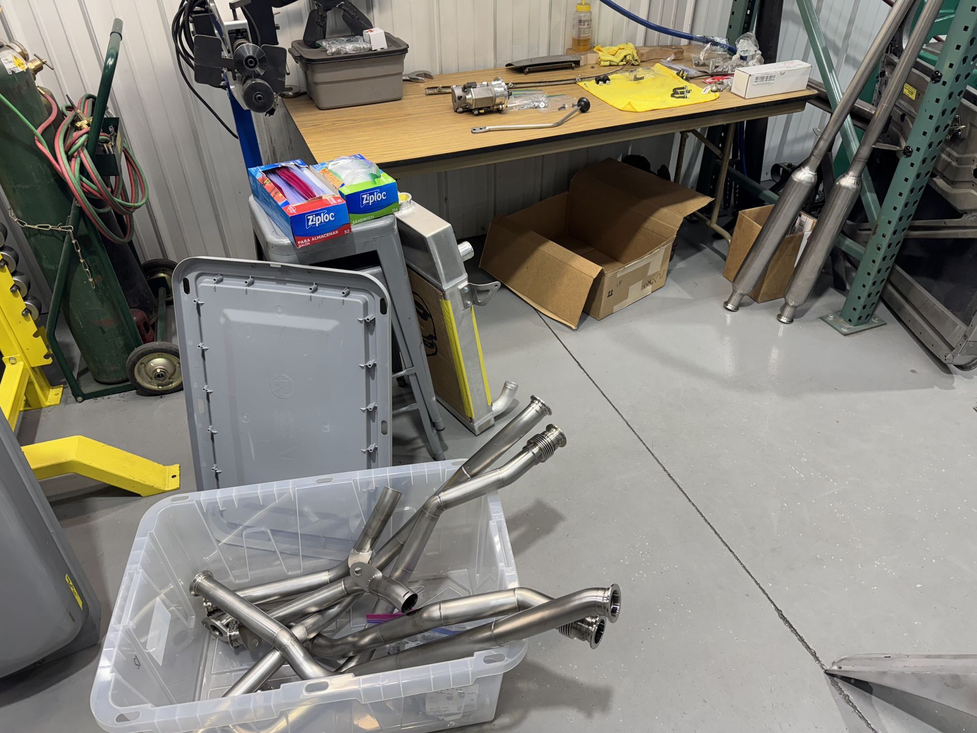 A bunch of metal pipes are sitting on the floor in a garage.