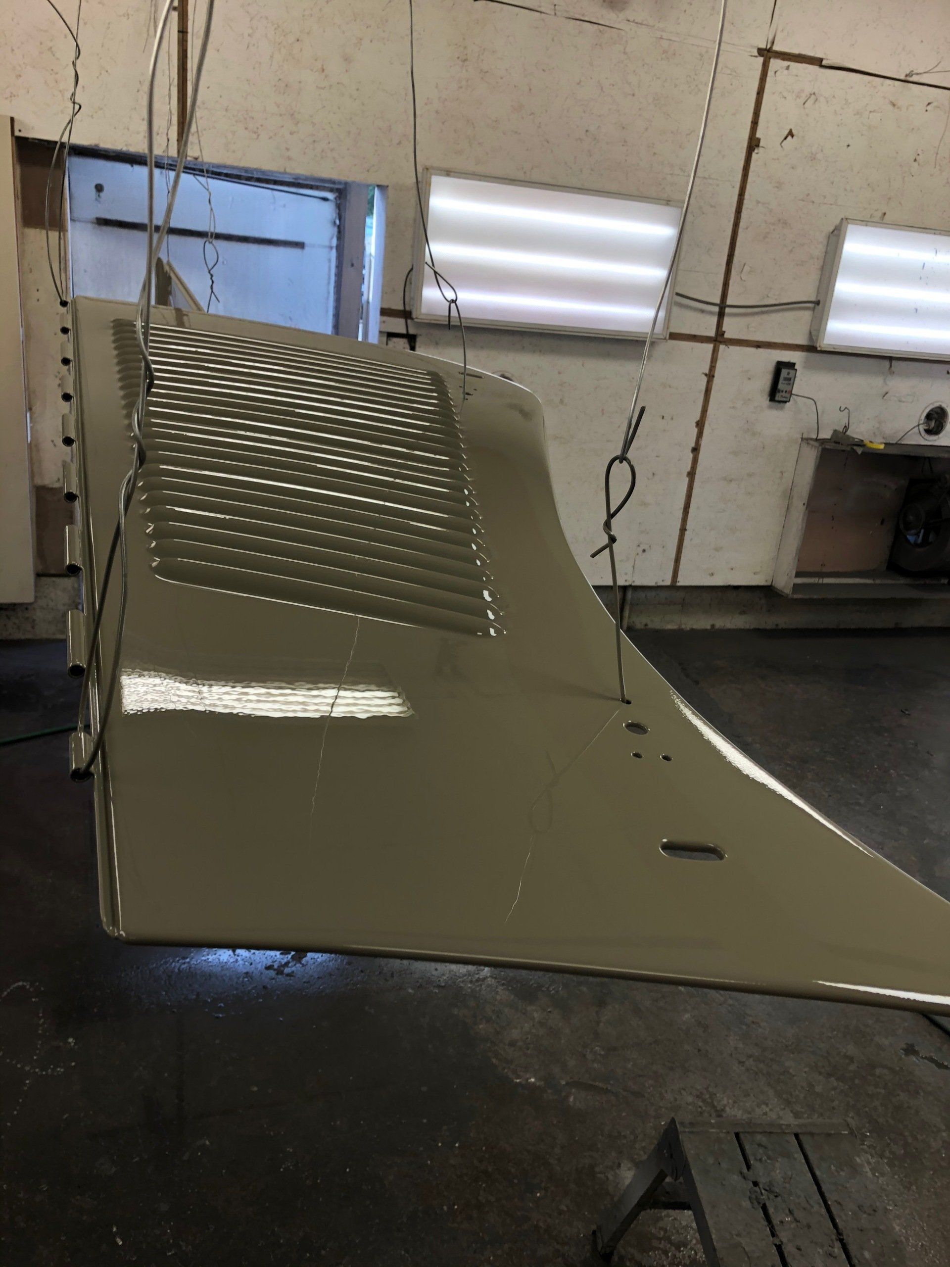 A large piece of metal is hanging from the ceiling in a room.