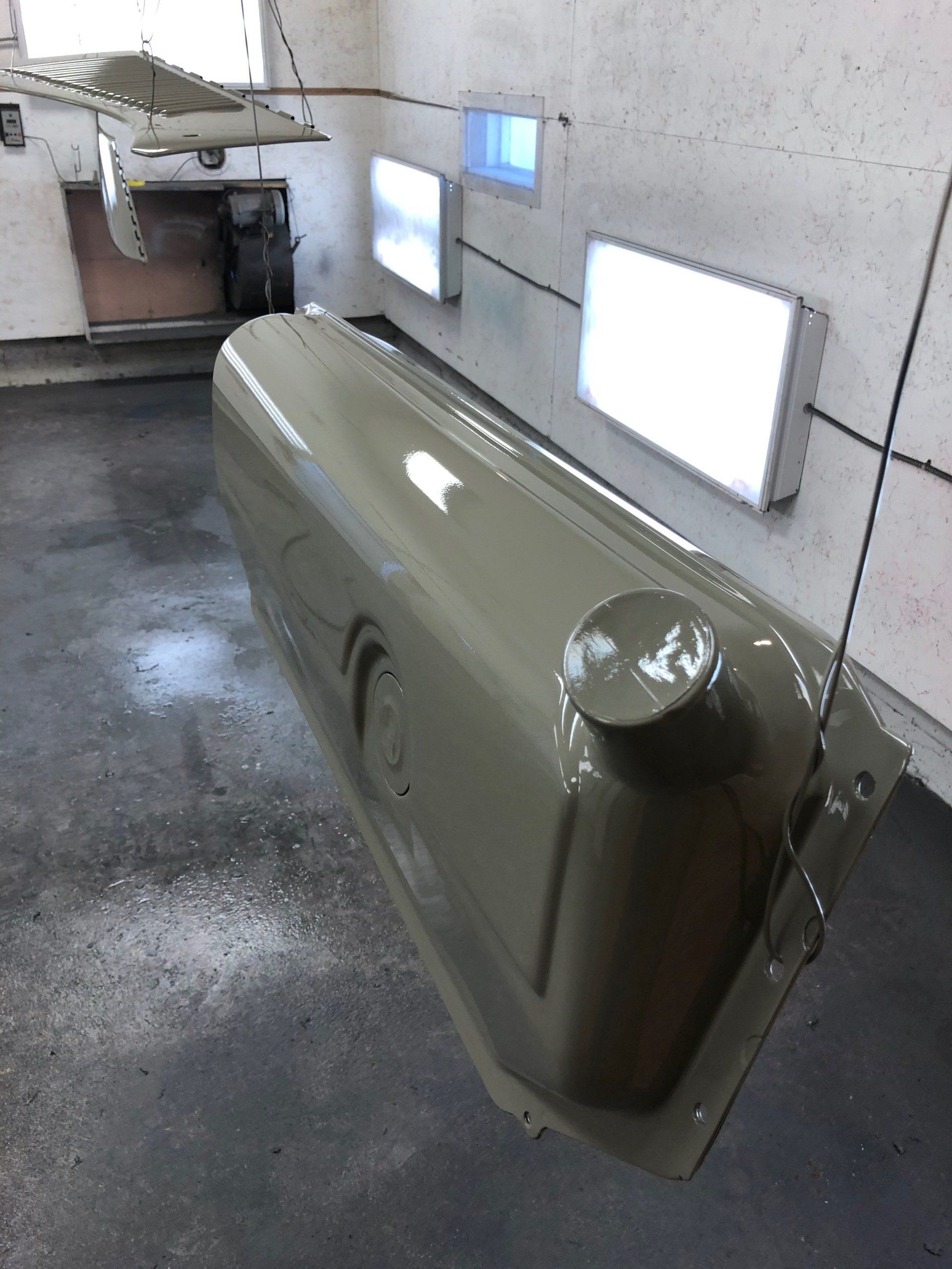 A gray tank is hanging from the ceiling in a room