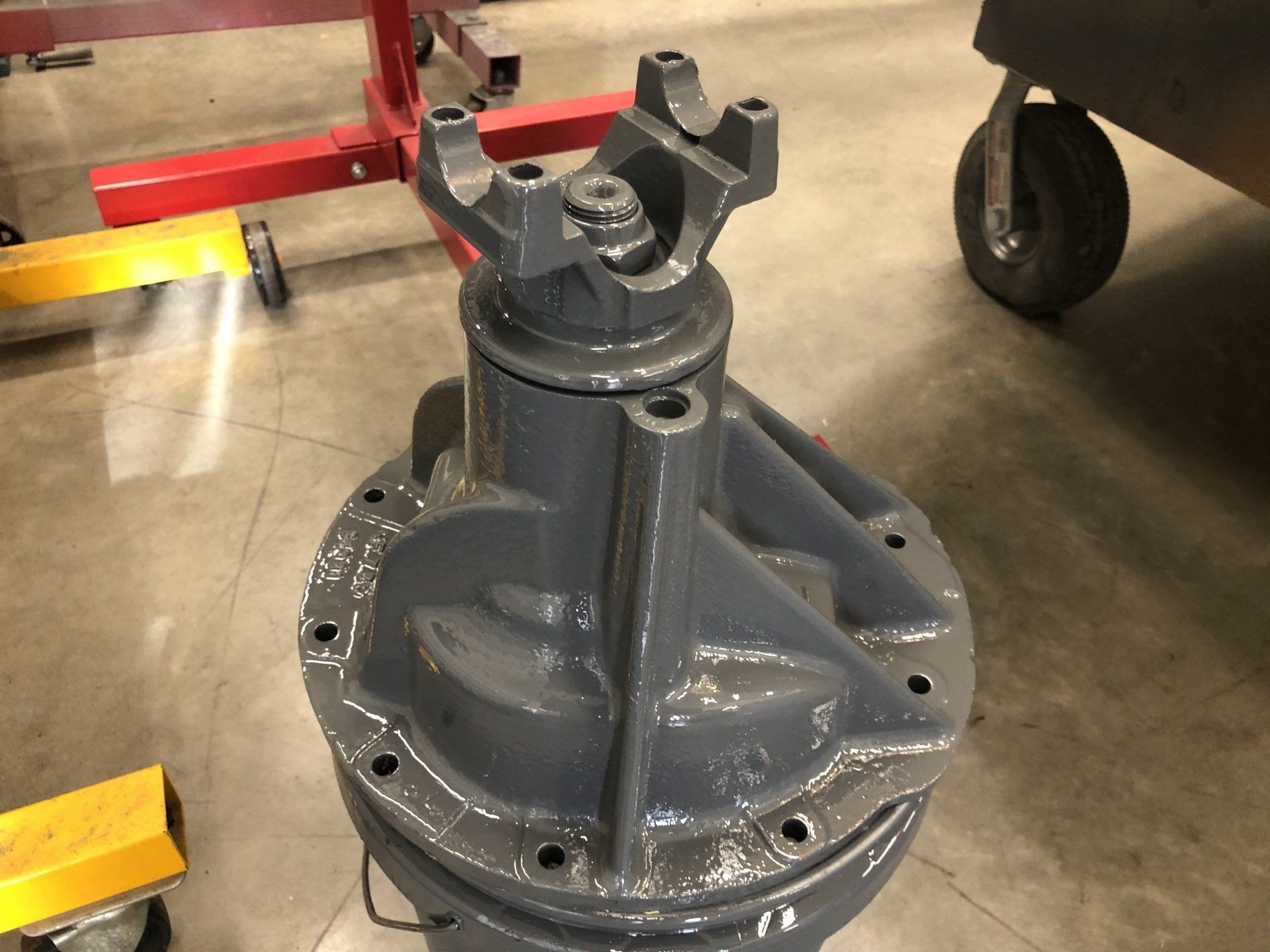 A gray metal object is sitting on a concrete floor.