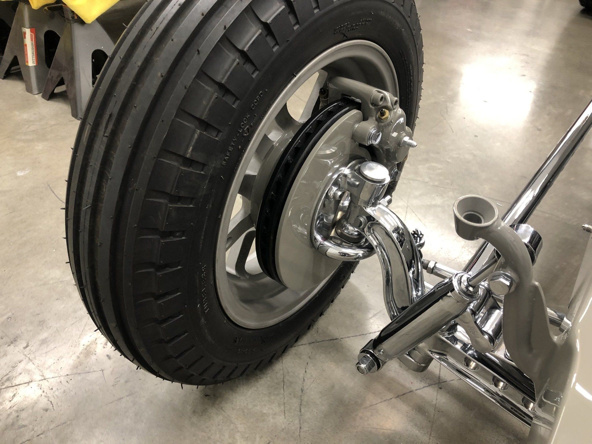 A close up of a tire on a car on a concrete floor.