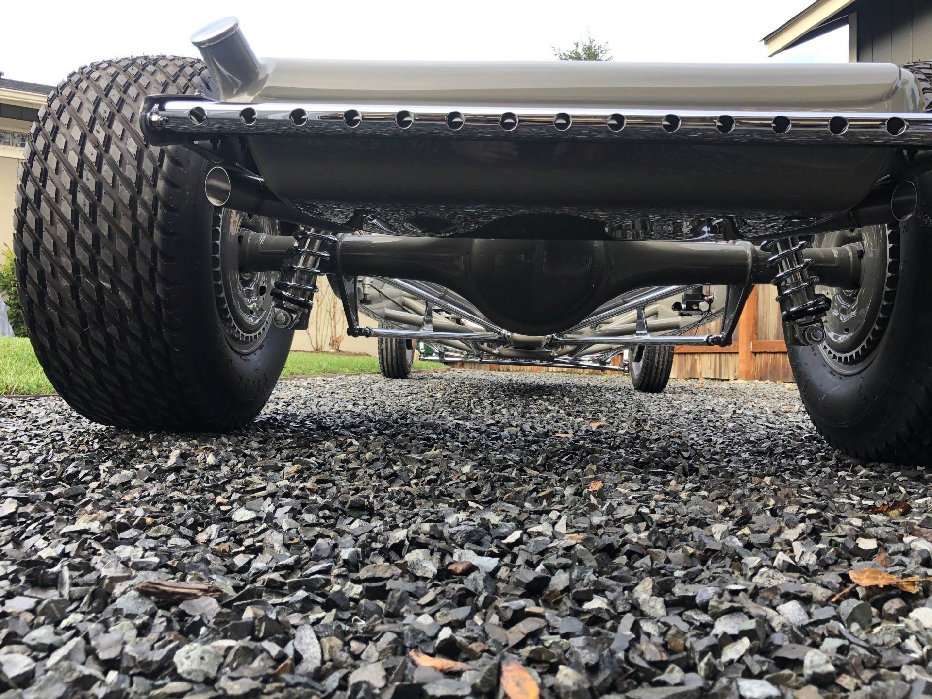 A close up of a car 's rear end on gravel.