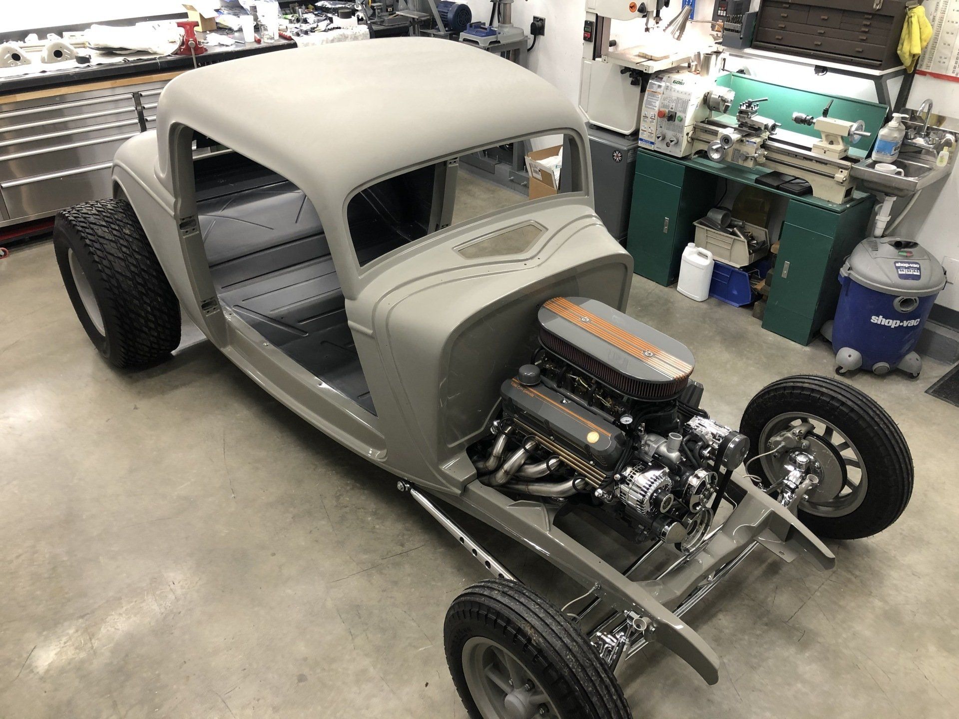 A hot rod is being built in a garage.