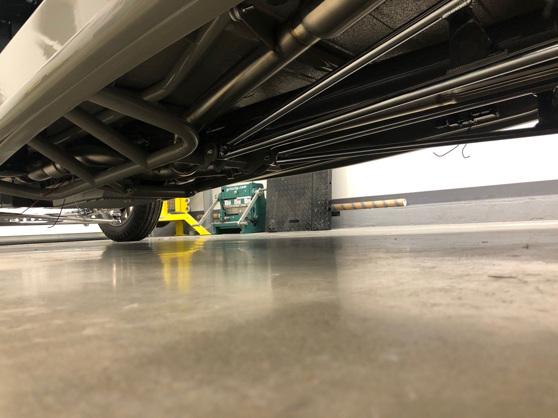 A car is parked on a concrete floor in a garage.