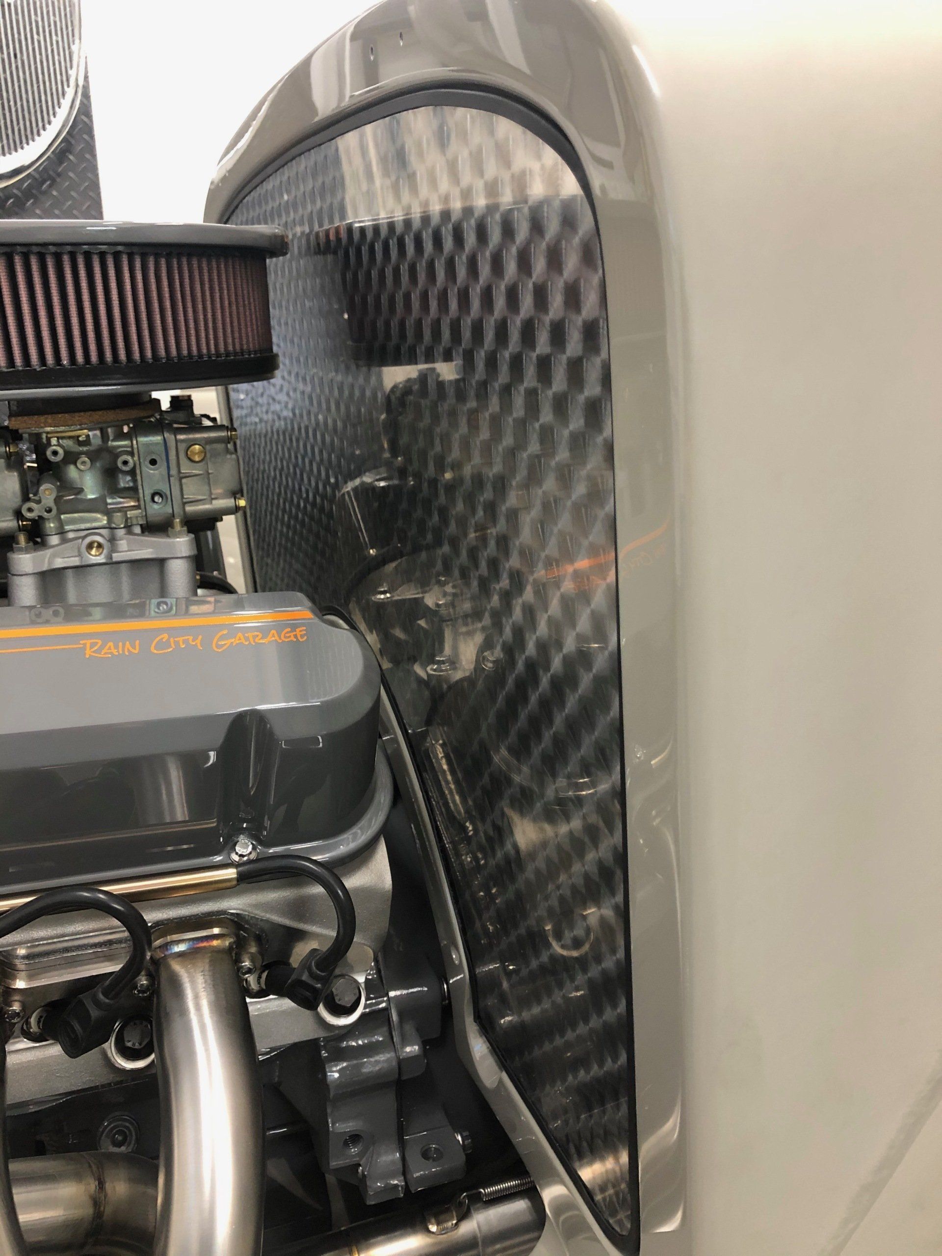 A close up of a car engine with a air filter on it.