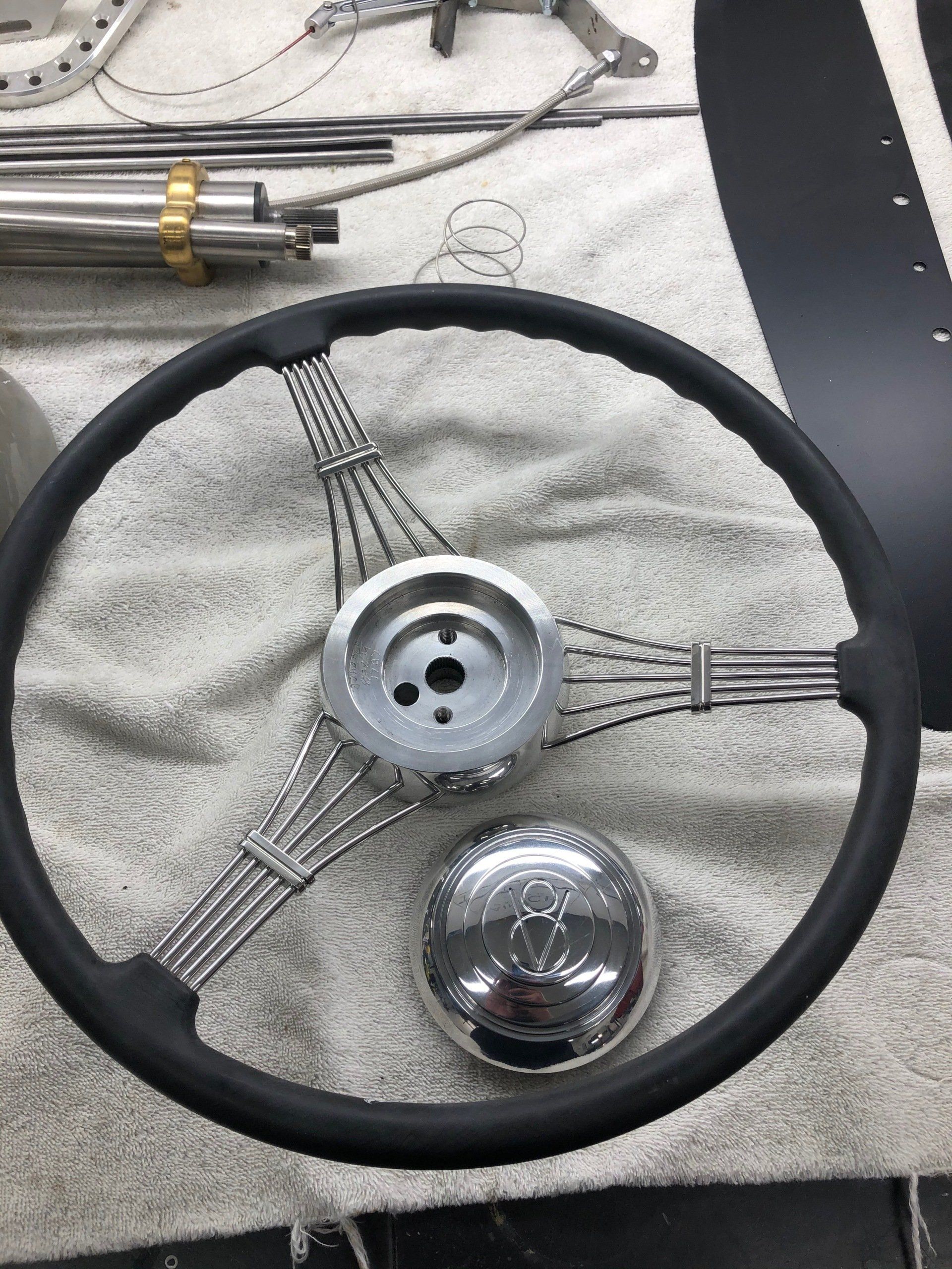 A black steering wheel is sitting on a white towel.