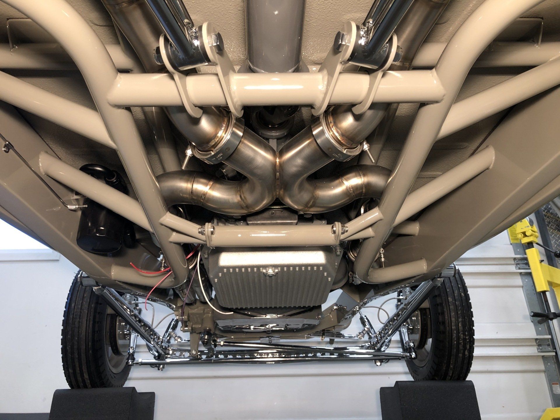A close up of the underside of a car with exhaust pipes