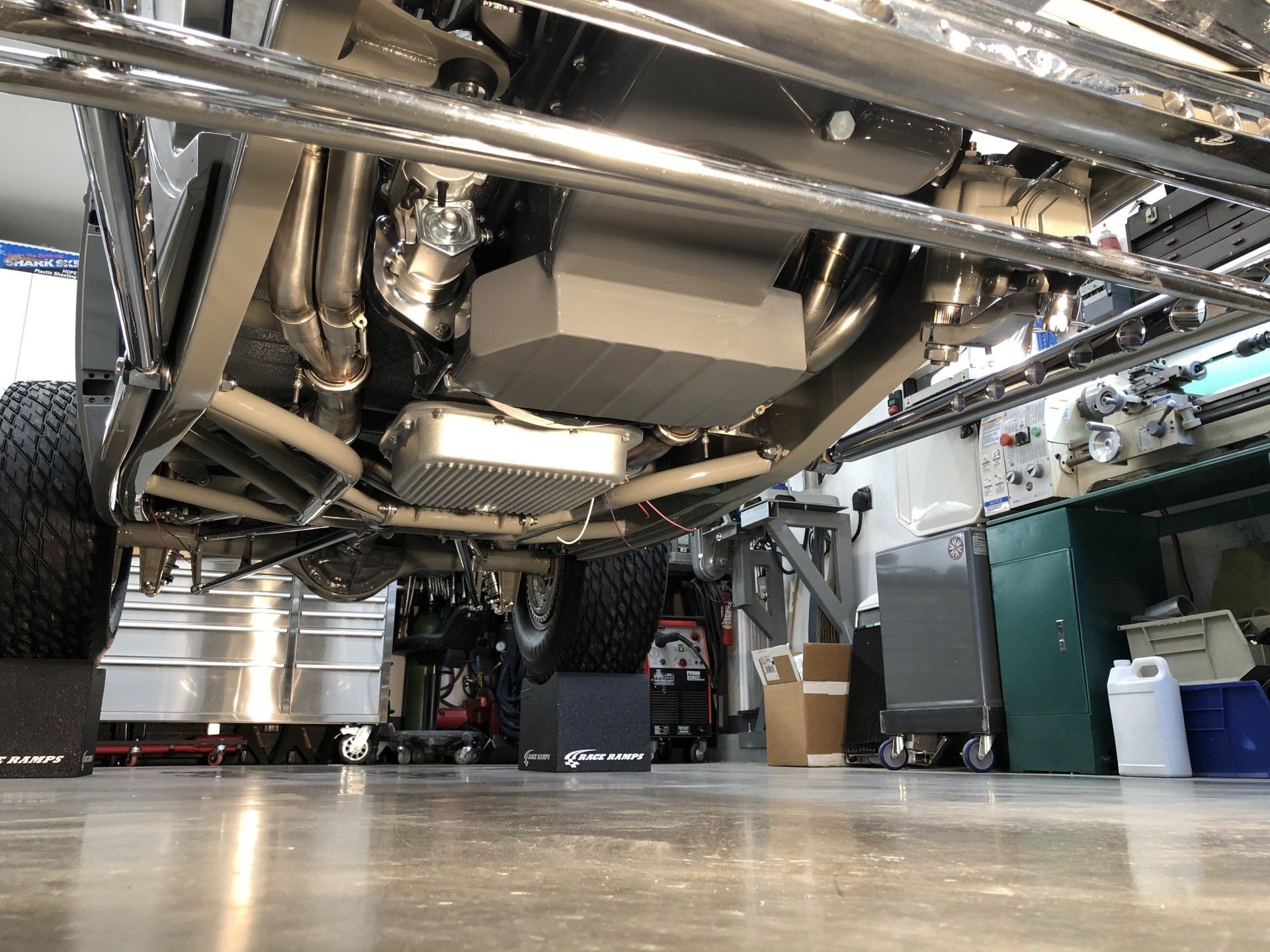 The underside of a car is shown in a garage