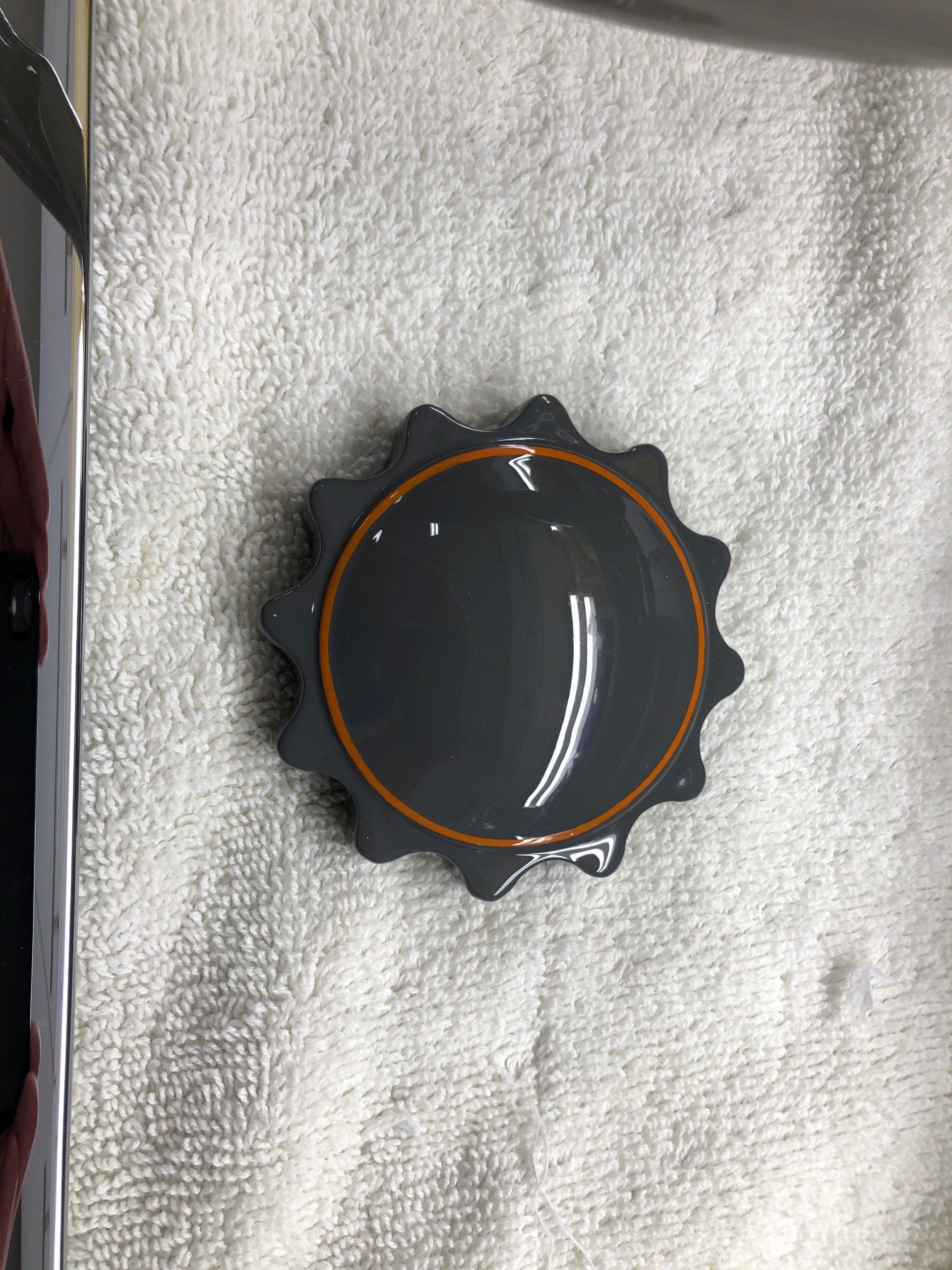 A small black object is sitting on top of a white towel.