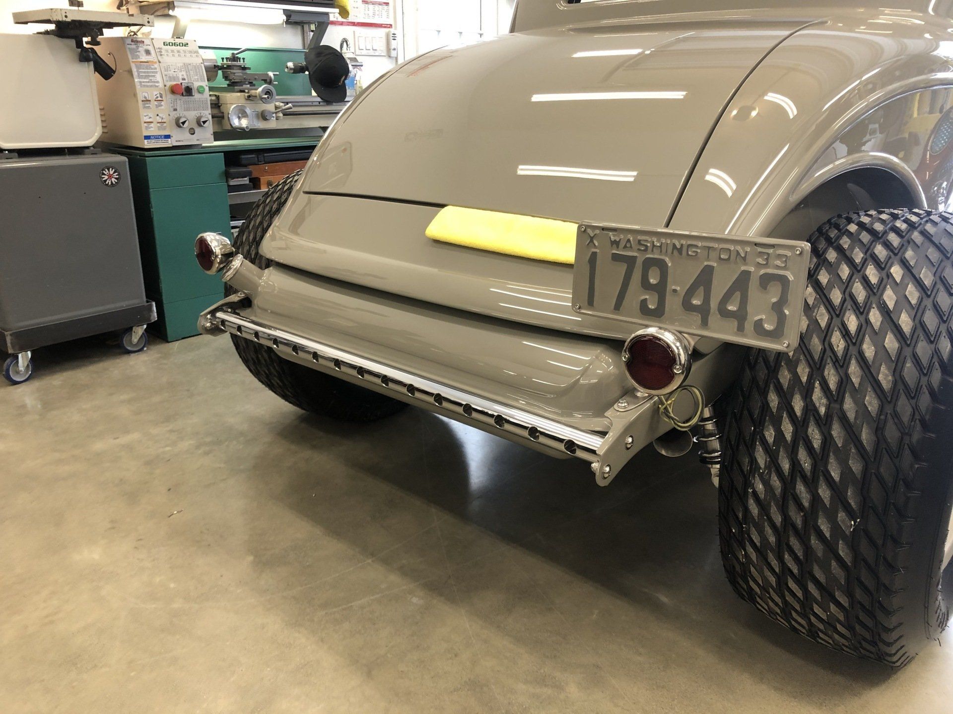 A car with a license plate that says 179 443 is parked in a garage.