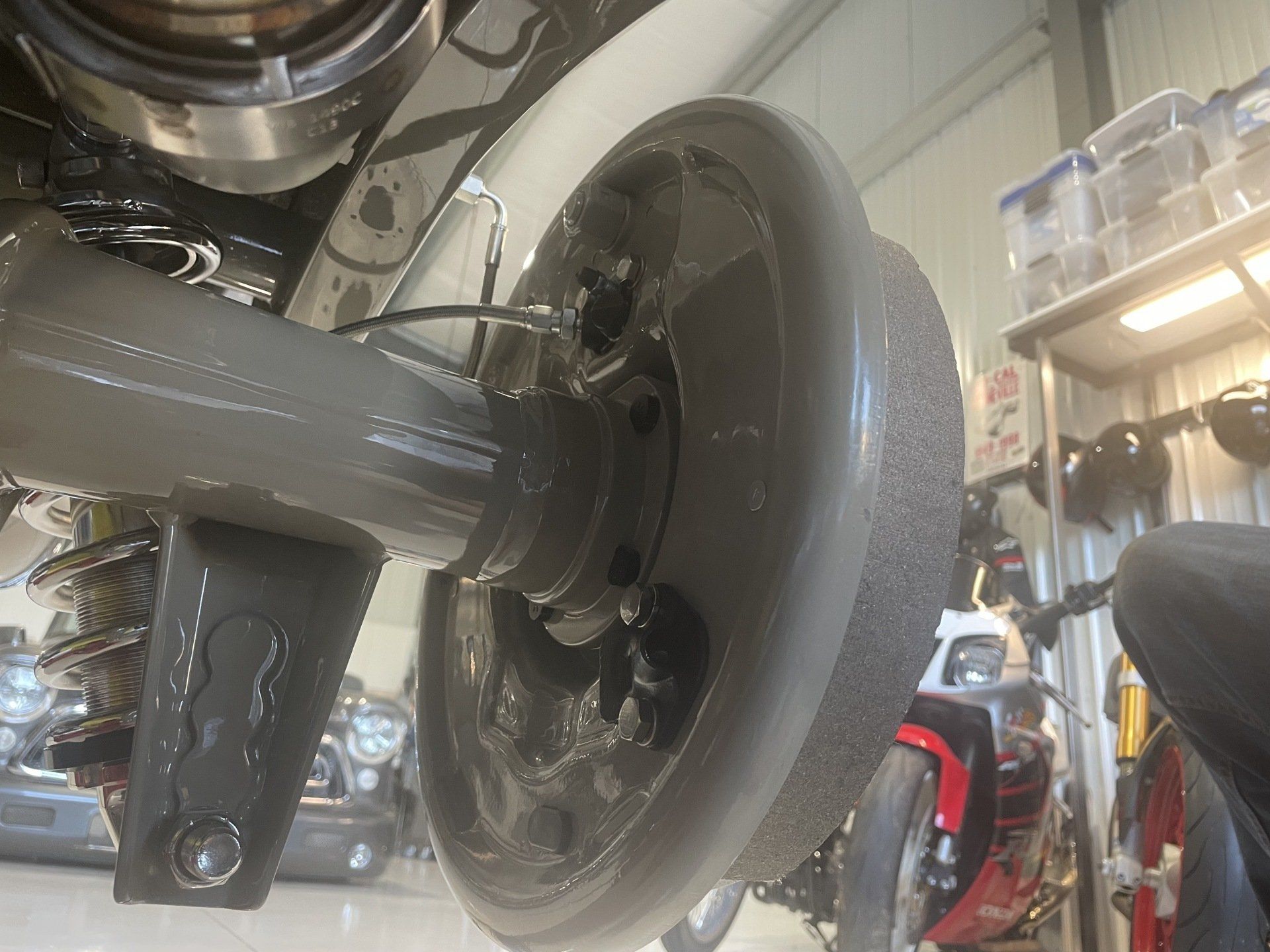 A close up of a car 's rear wheel in a garage.