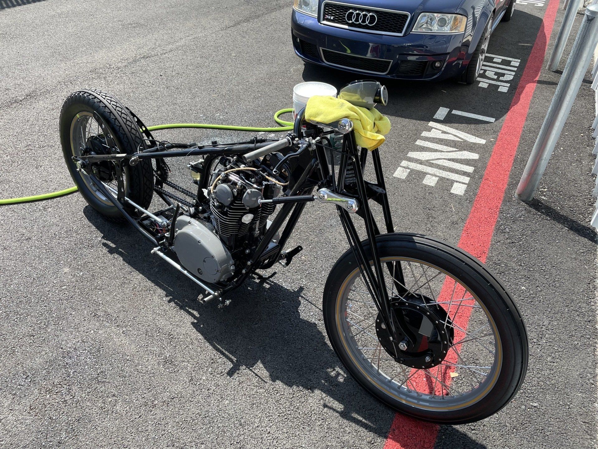 A motorcycle is parked on the side of the road next to a car.