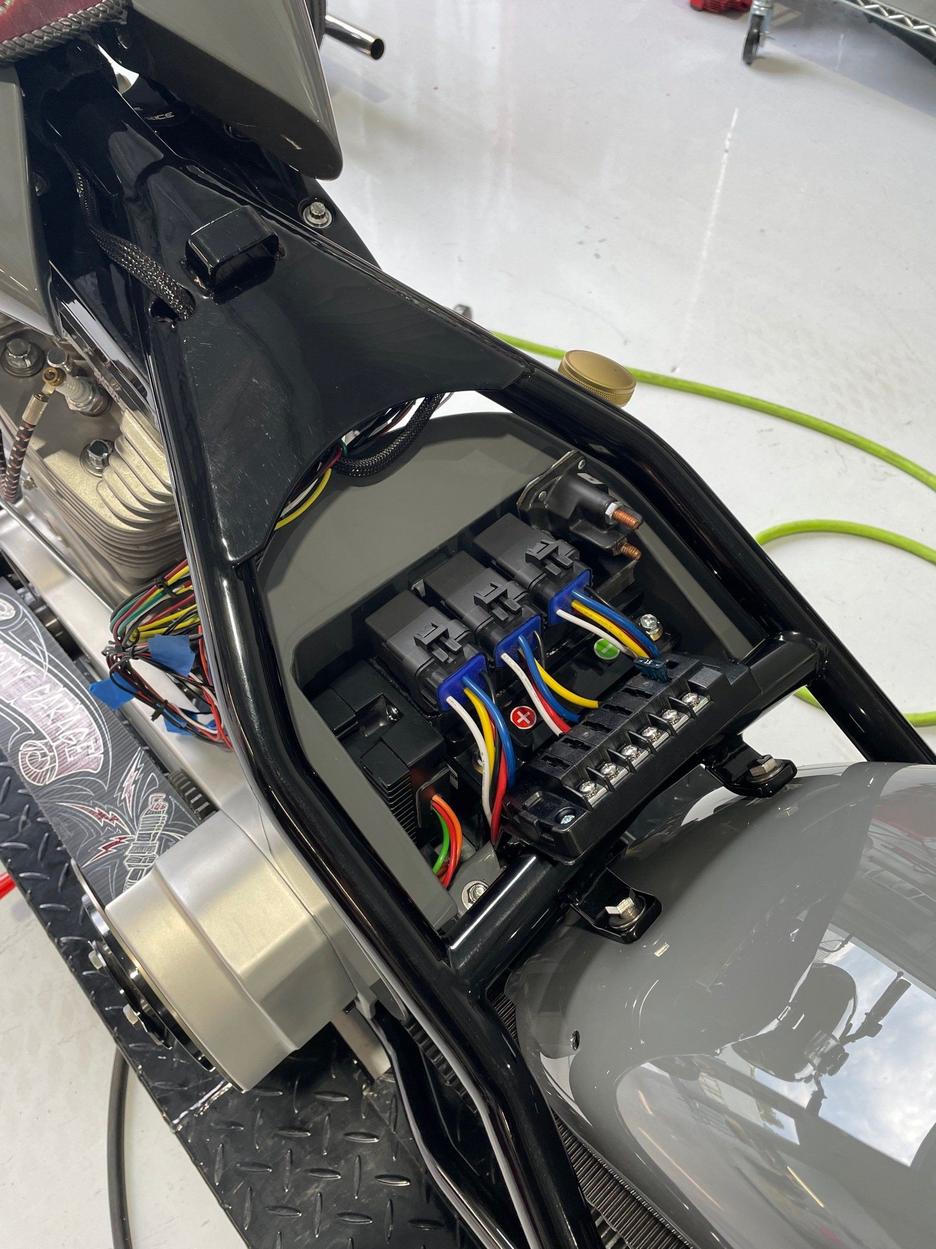 The inside of a motorcycle with a lot of wires coming out of it.