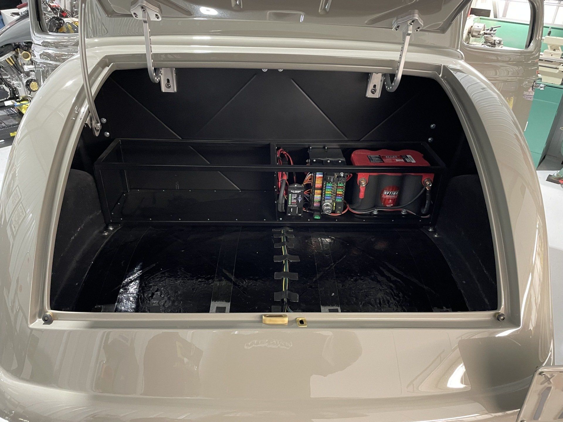The back of a car with the trunk open and a battery in it
