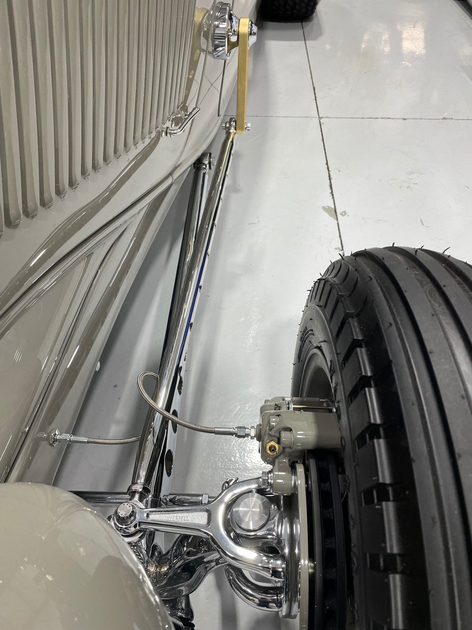 A close up of a car 's rear suspension in a garage.