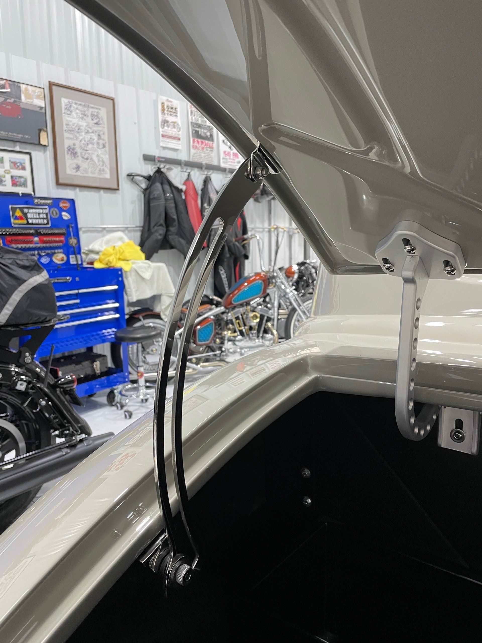 The hood of a car is open in a garage.