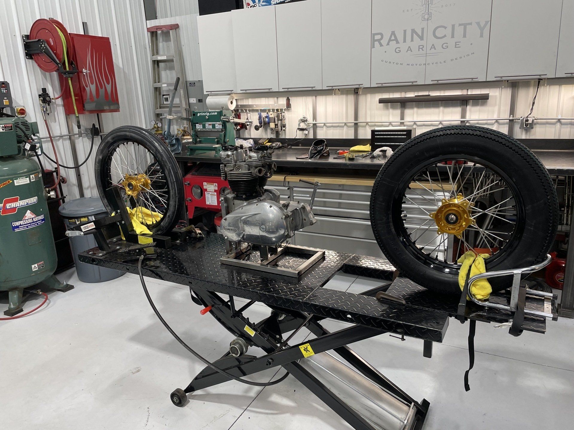 A motorcycle is sitting on a lift in a garage.