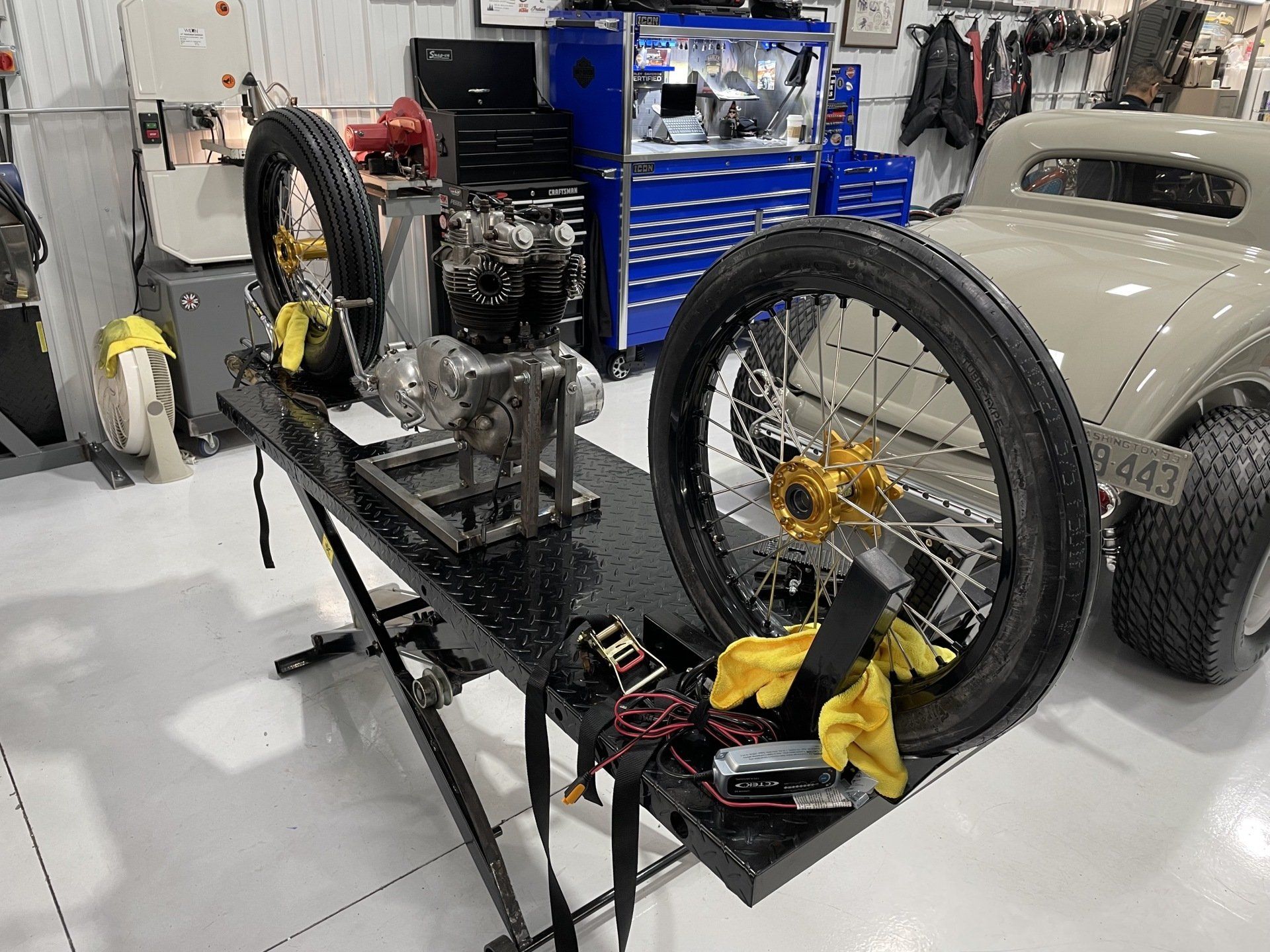 A motorcycle engine is sitting on top of a table in a garage.
