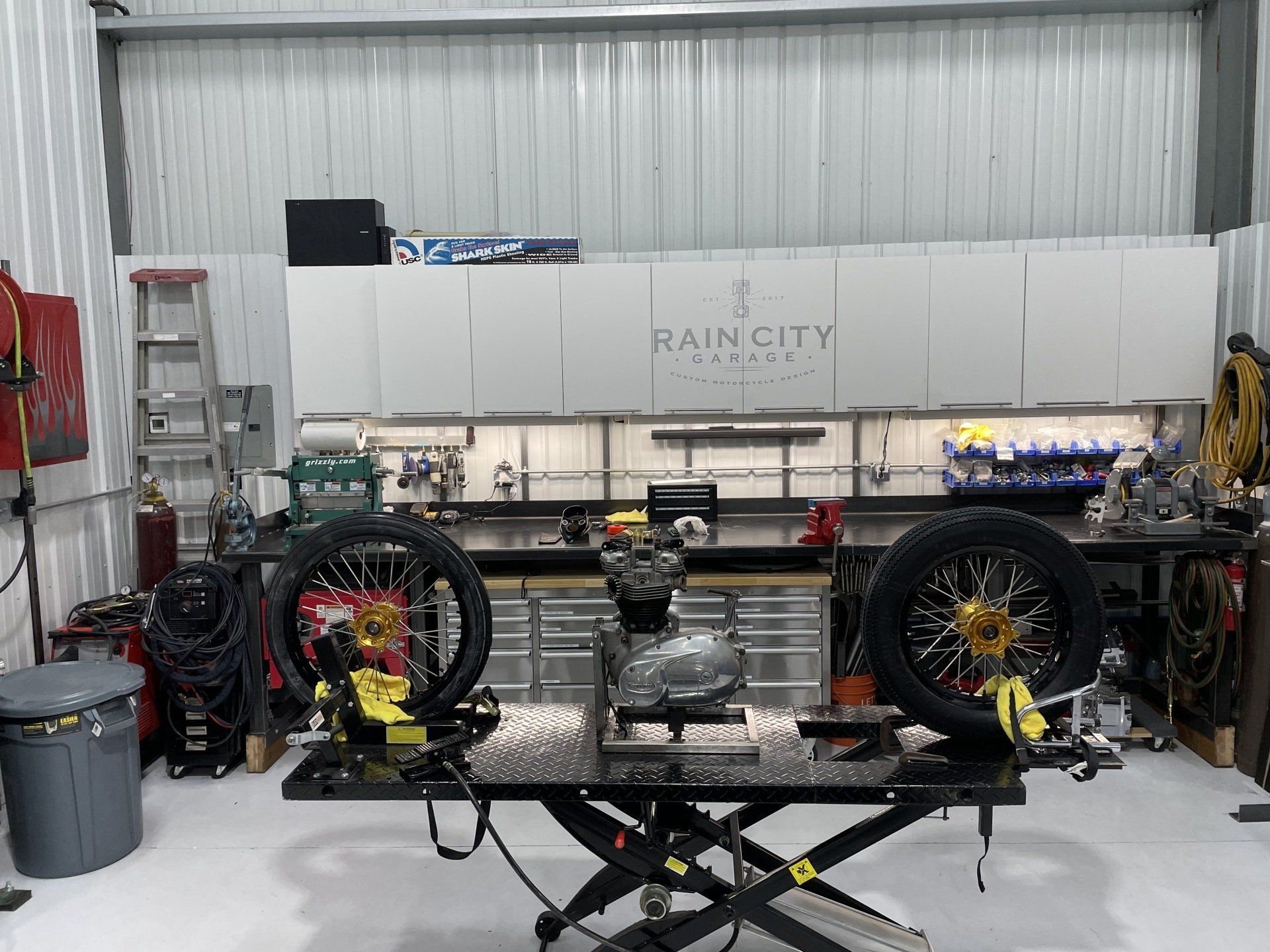 A motorcycle is sitting on top of a table in a garage.