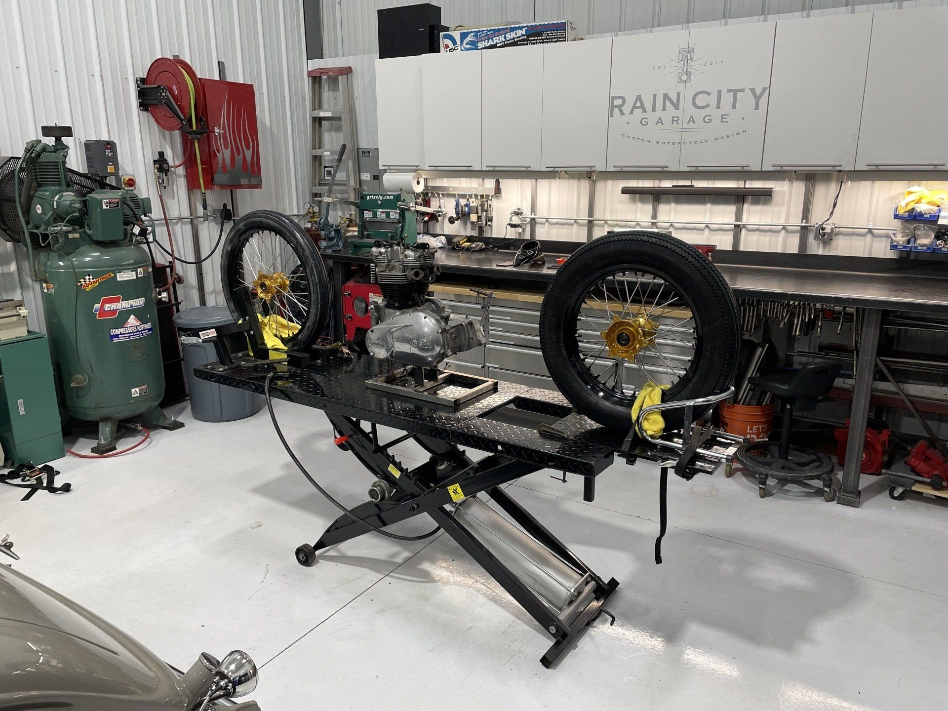 A motorcycle is being worked on in a garage.