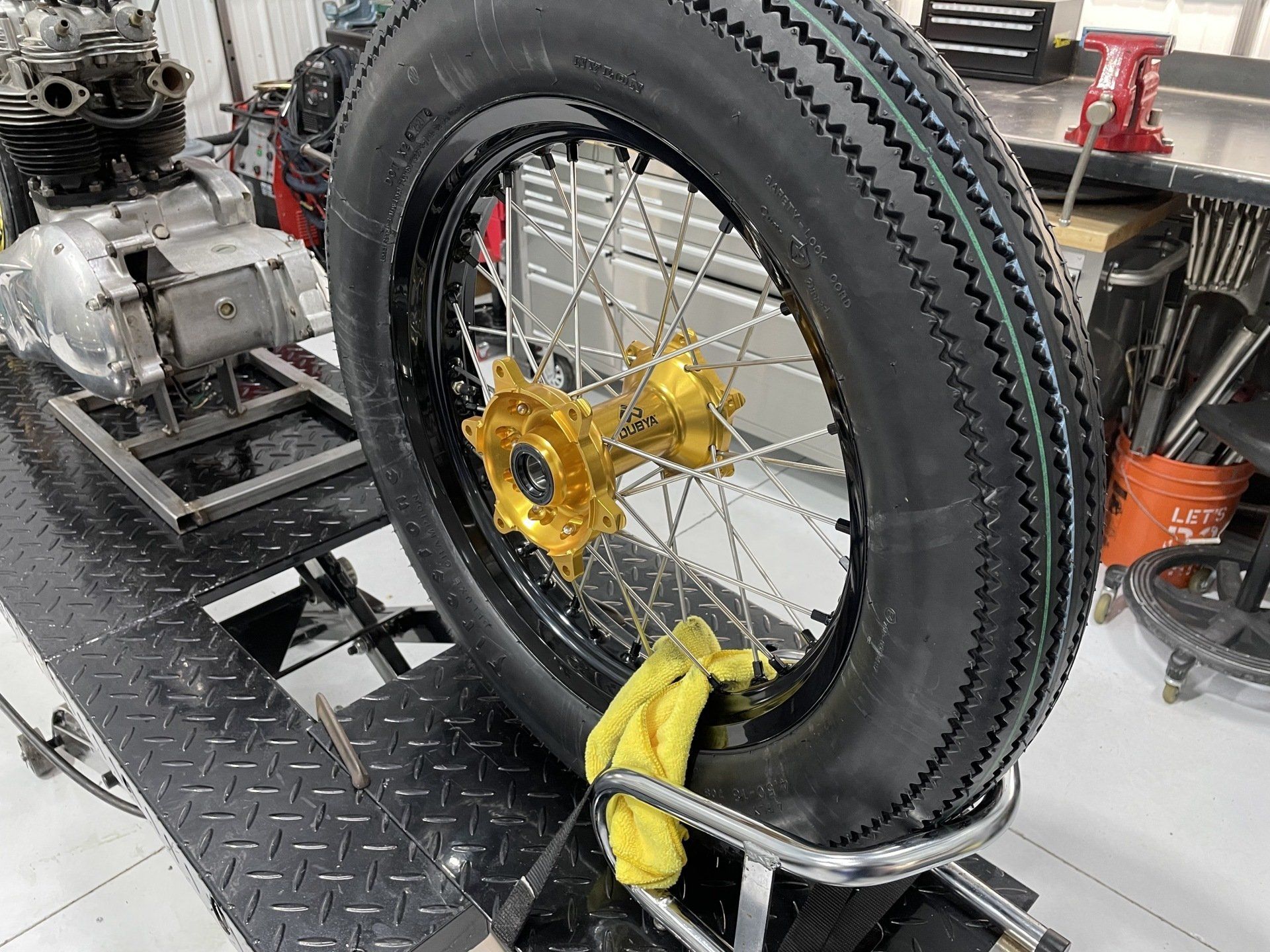 A motorcycle tire is sitting on top of a metal stand in a garage.