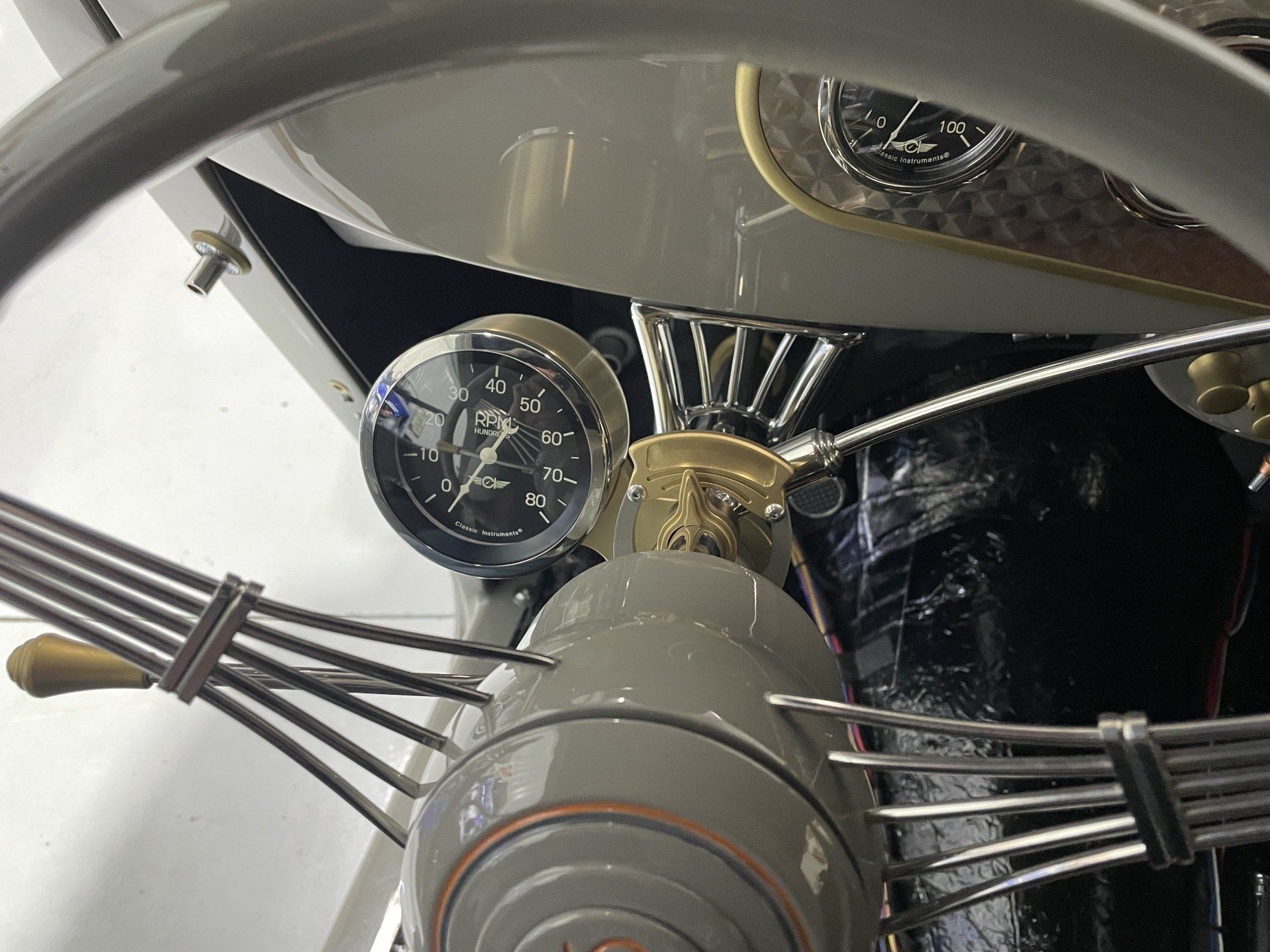 A close up of a steering wheel with a clock on it