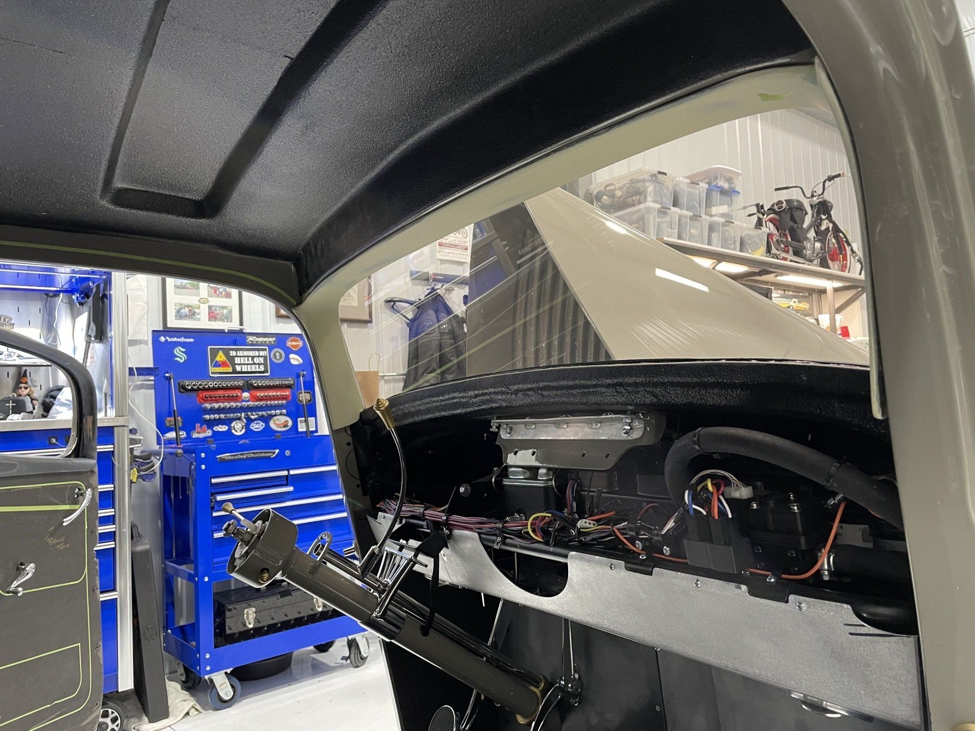 The inside of a car is being worked on in a garage.