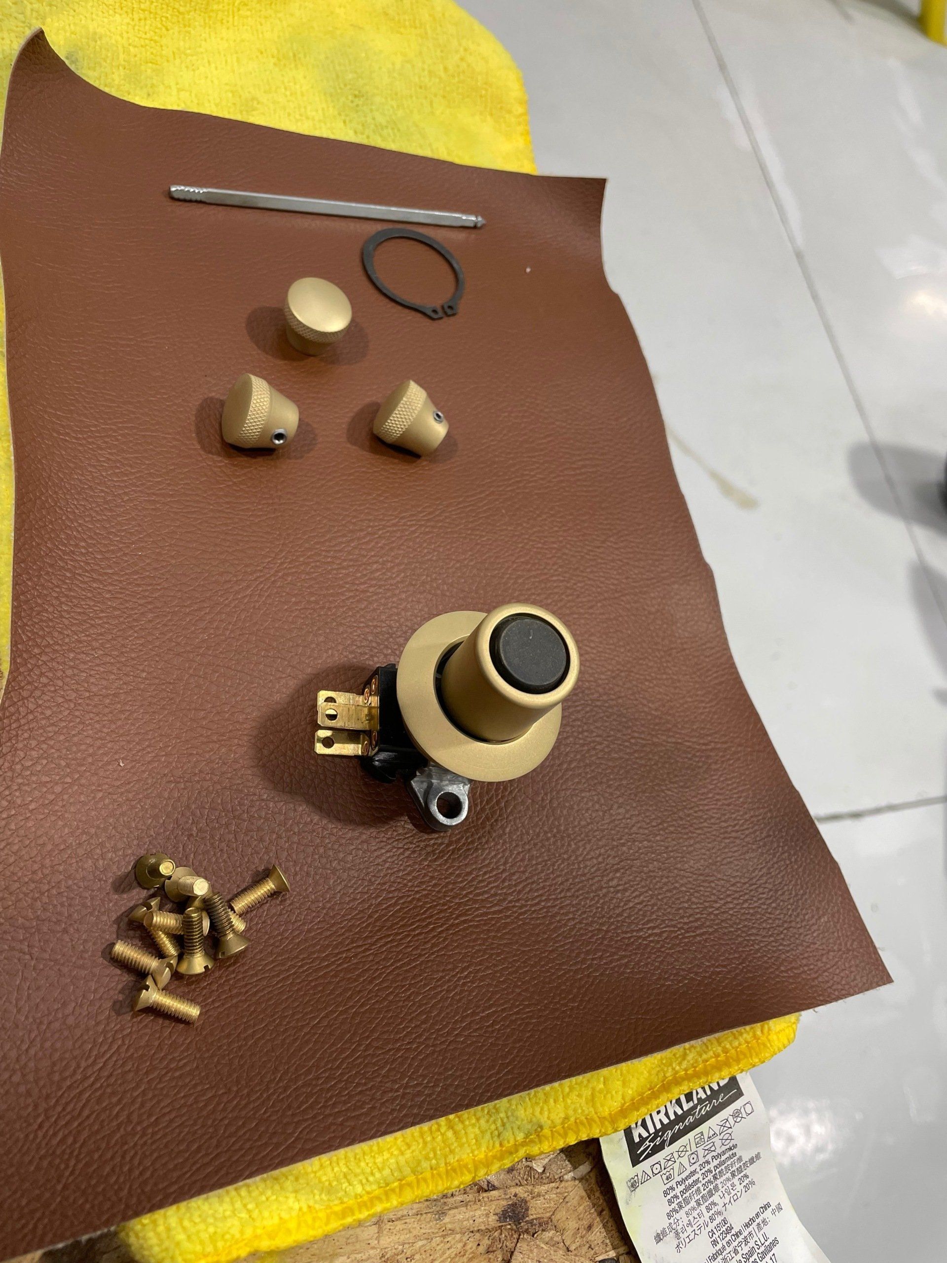 A piece of brown paper with brass parts on it