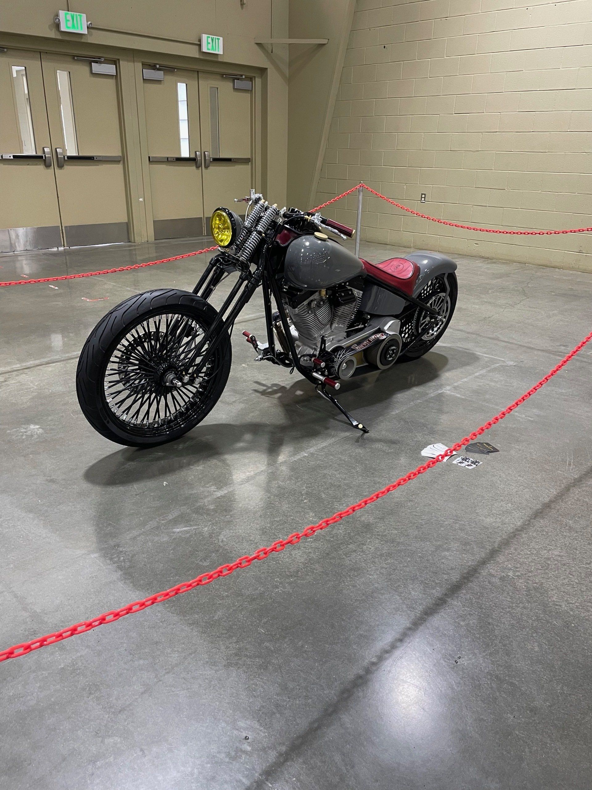 A motorcycle is parked in a room with a red rope around it.