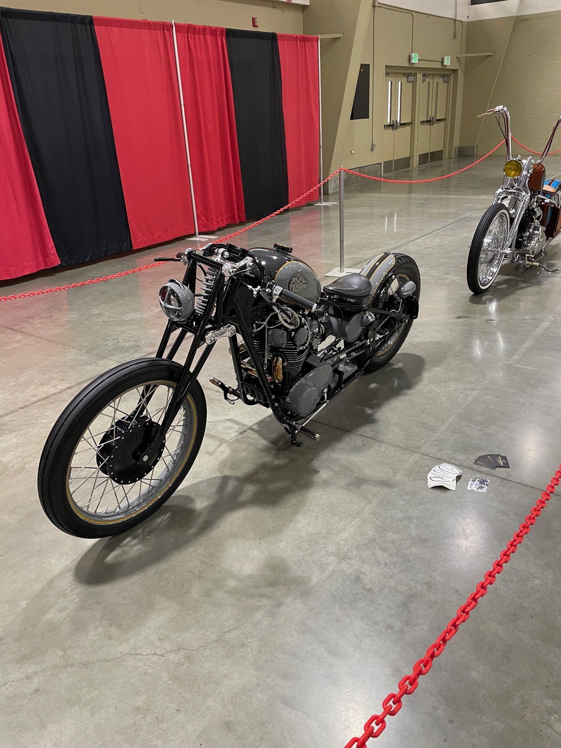 A motorcycle is parked in a room next to another motorcycle.