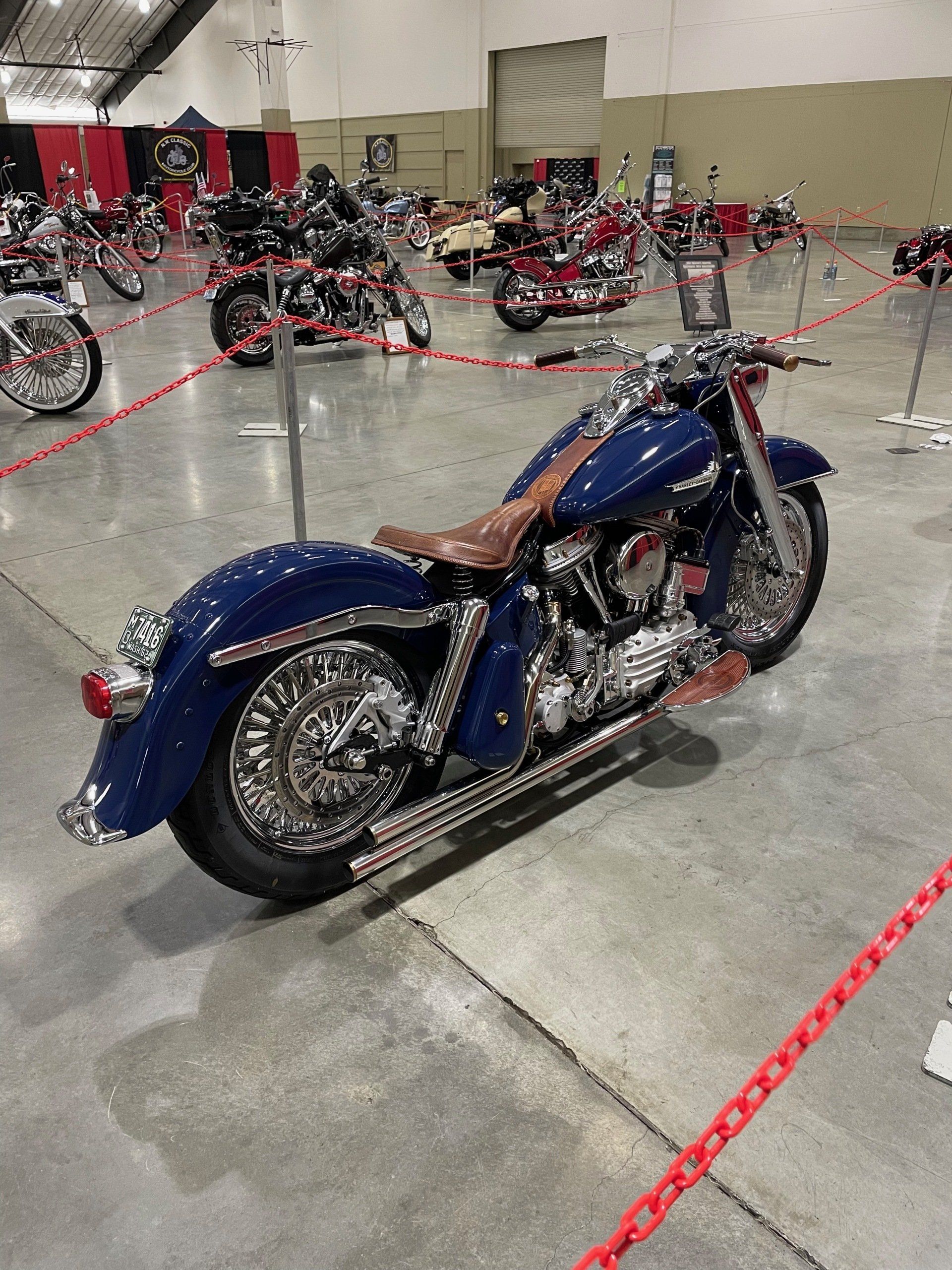 A blue motorcycle is parked in a room with other motorcycles.
