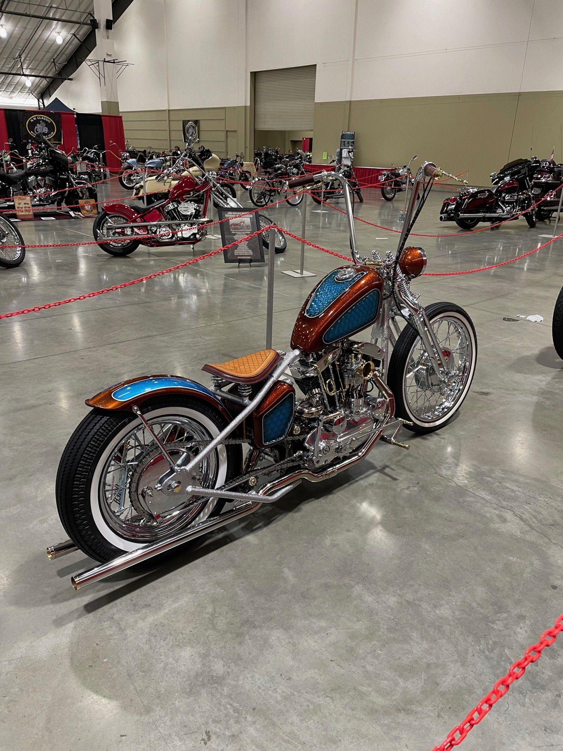 A chopper motorcycle is parked in a warehouse.