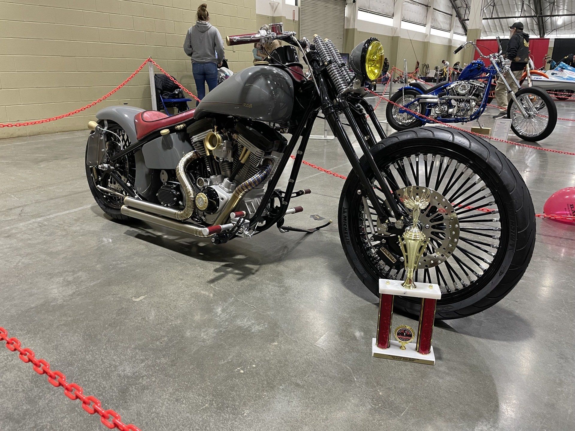 A motorcycle is parked in a warehouse next to a trophy.