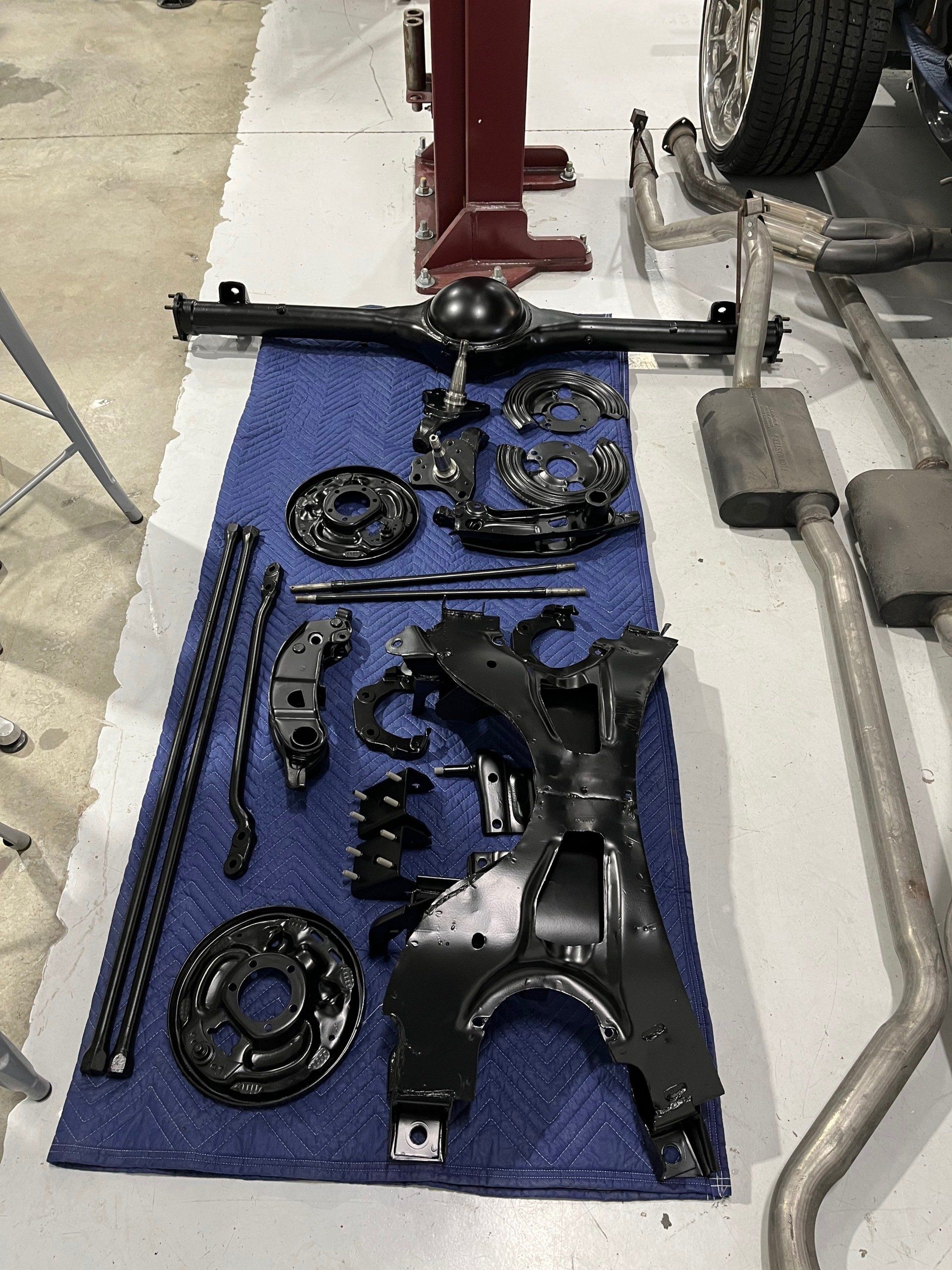 A bunch of parts of a car are sitting on a blue towel.