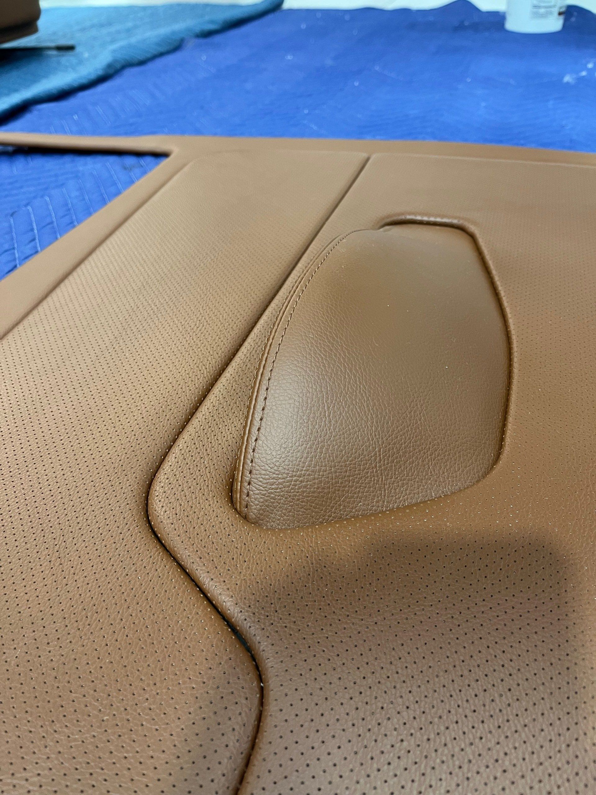 A close up of a piece of brown leather on a blue surface