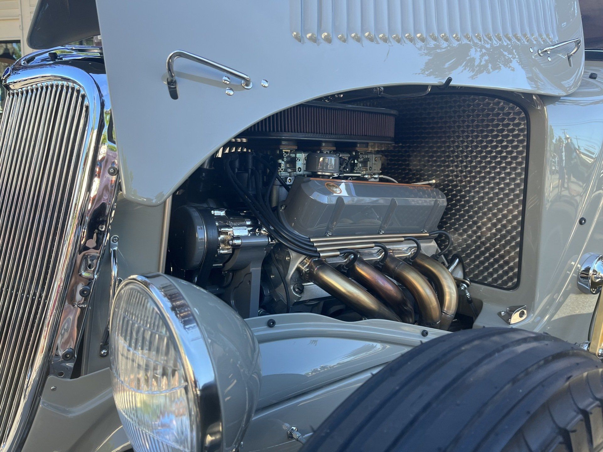 A close up of a car engine with the hood open