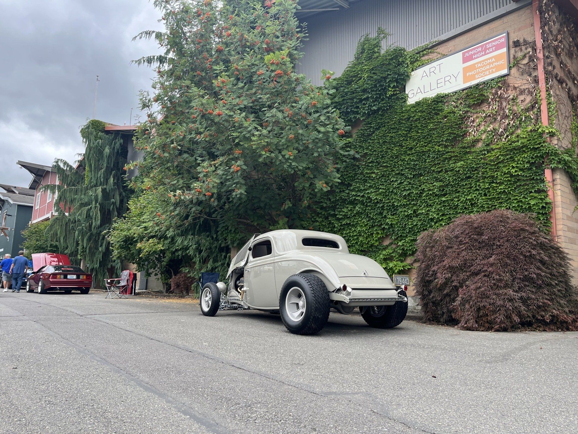 A white car is parked on the side of the road in front of a building.