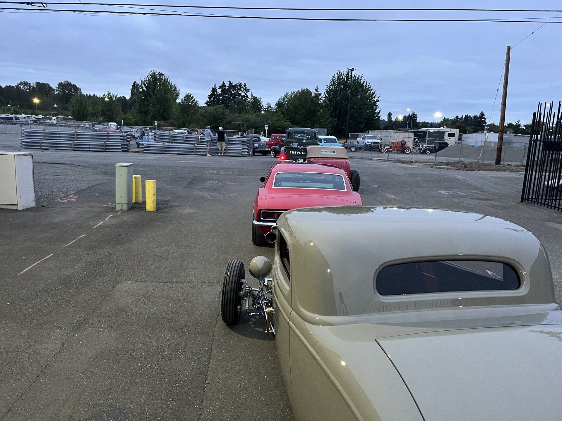 A row of old cars are parked in a parking lot.