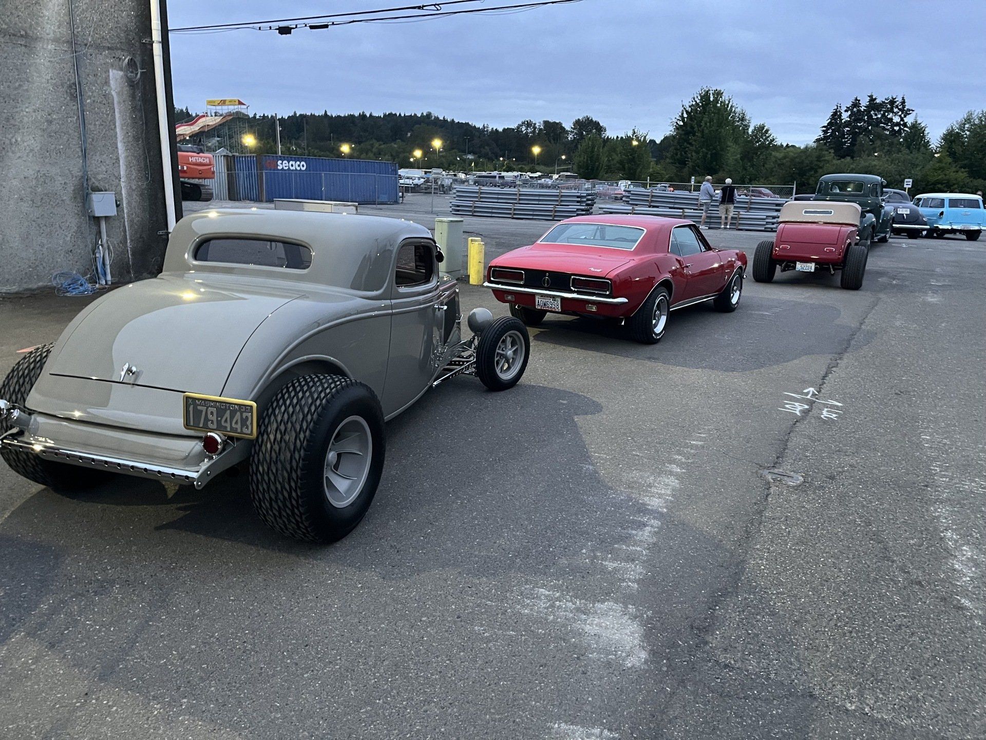 A row of old cars are parked in a parking lot