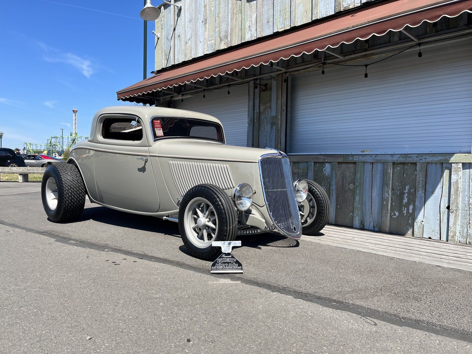 A classic car is parked in front of a building.