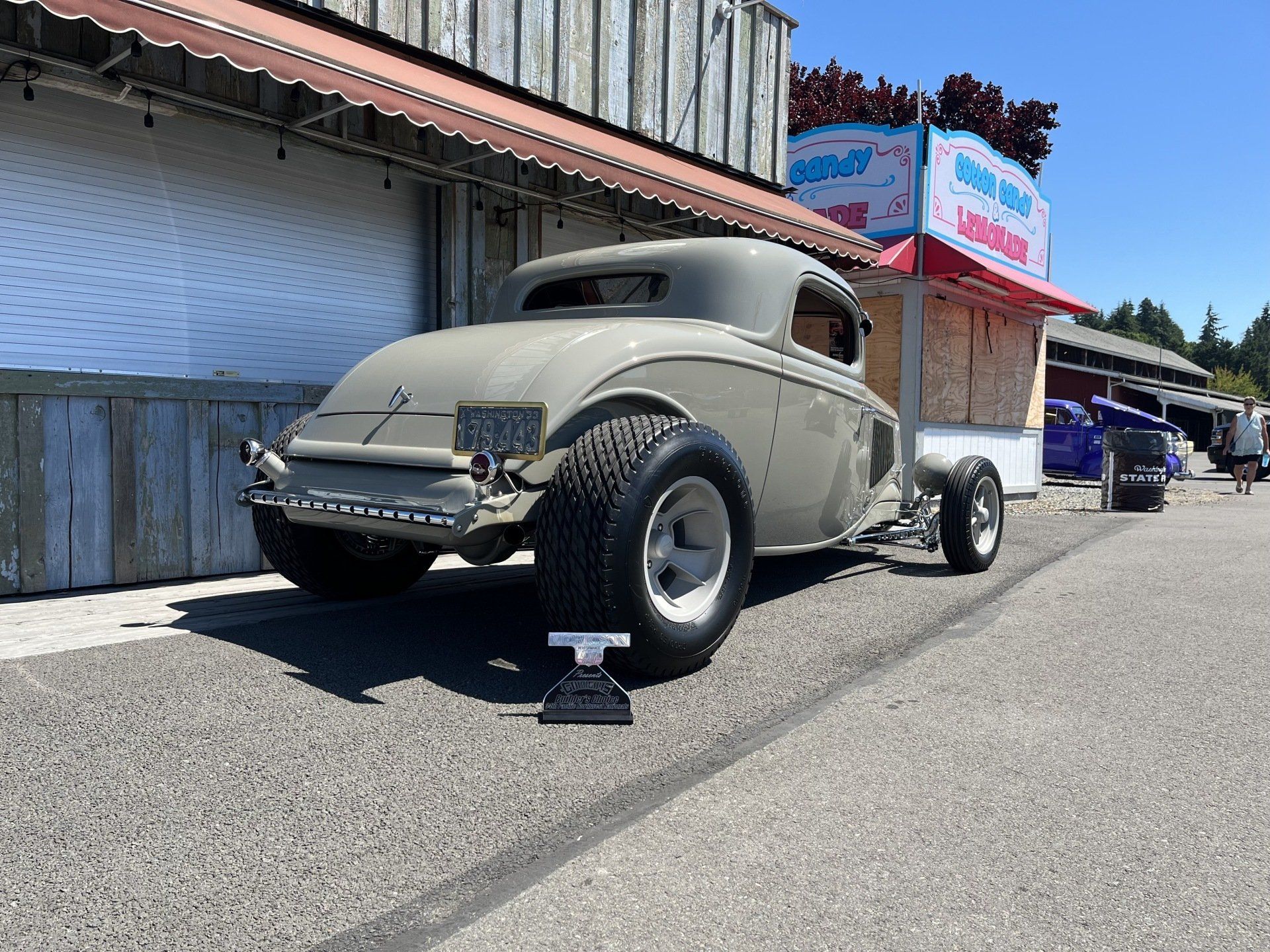 A car is parked on the side of the road in front of a building.