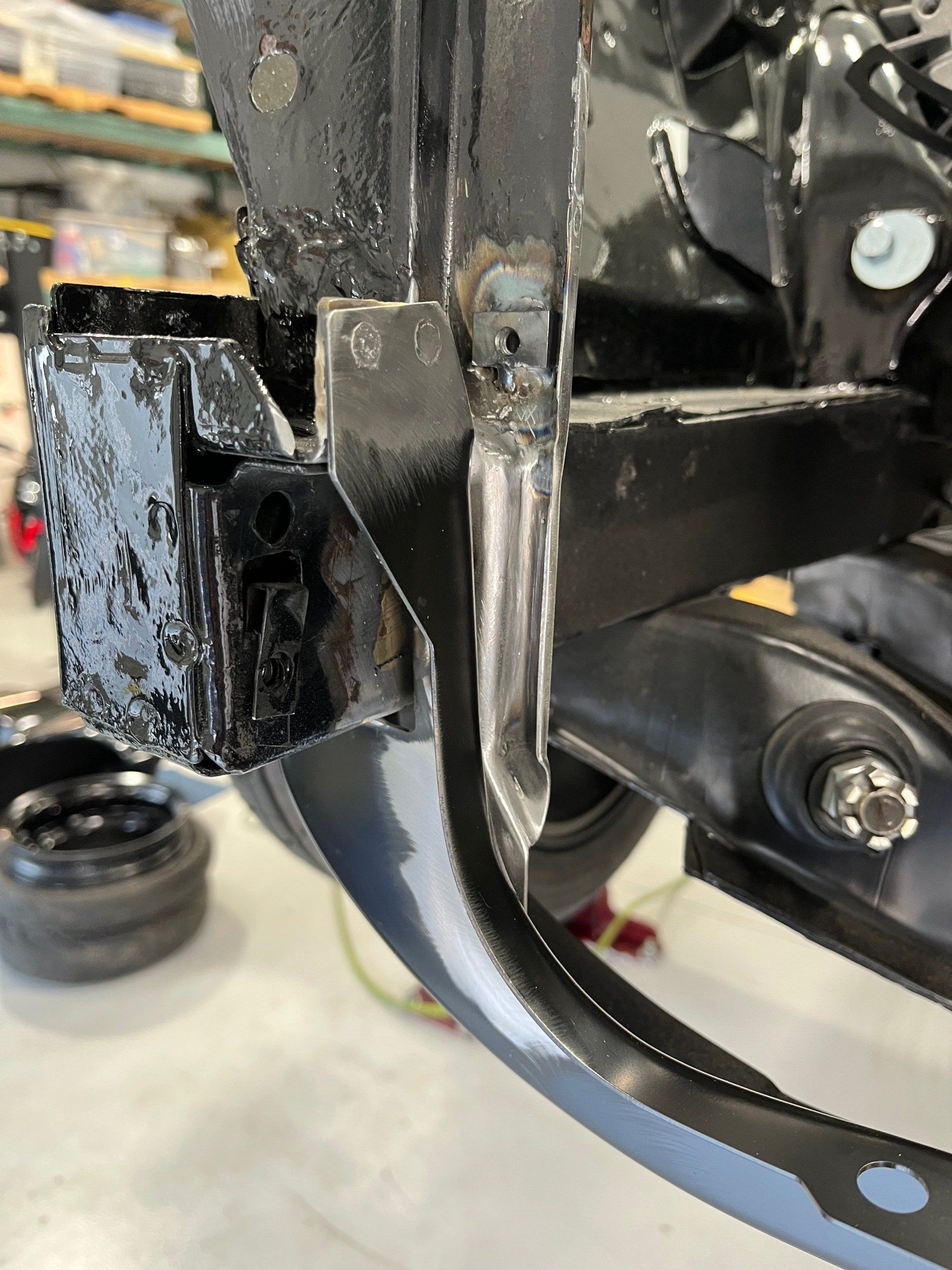 A close up of a piece of metal on a car in a garage.